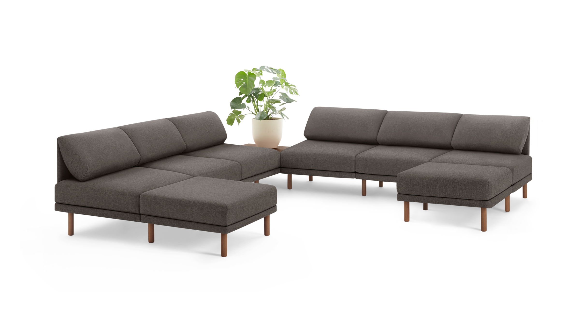 modern l - shaped sectional sofa with wooden legs and dark gray fabric upholstery, featuring a matching ottoman, a plant, and a