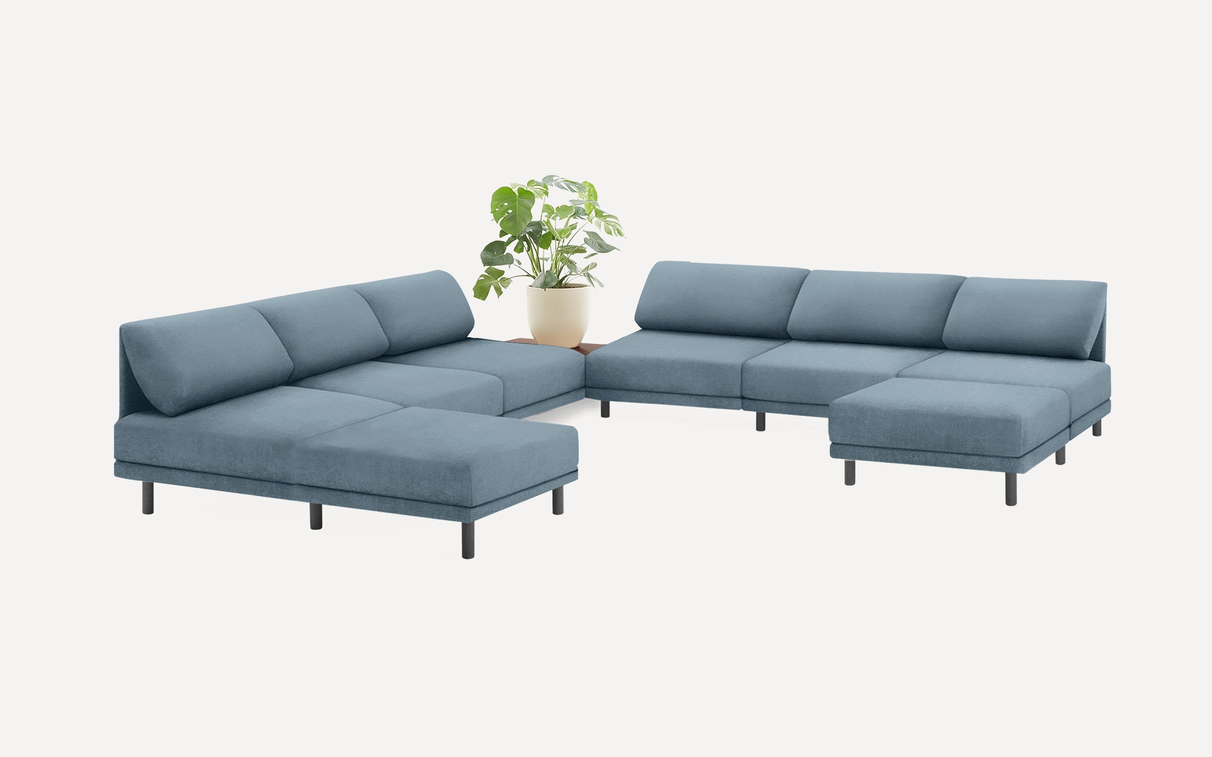 modern blue fabric sectional sofa with black metal legs and matching ottoman, featuring a plant on top of the sectional