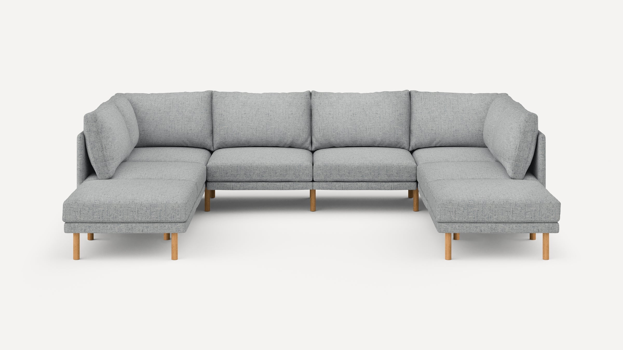 Modern sectional sofa with light gray fabric upholstery, wooden legs, and cushioned backrests, forming a U-shape design.