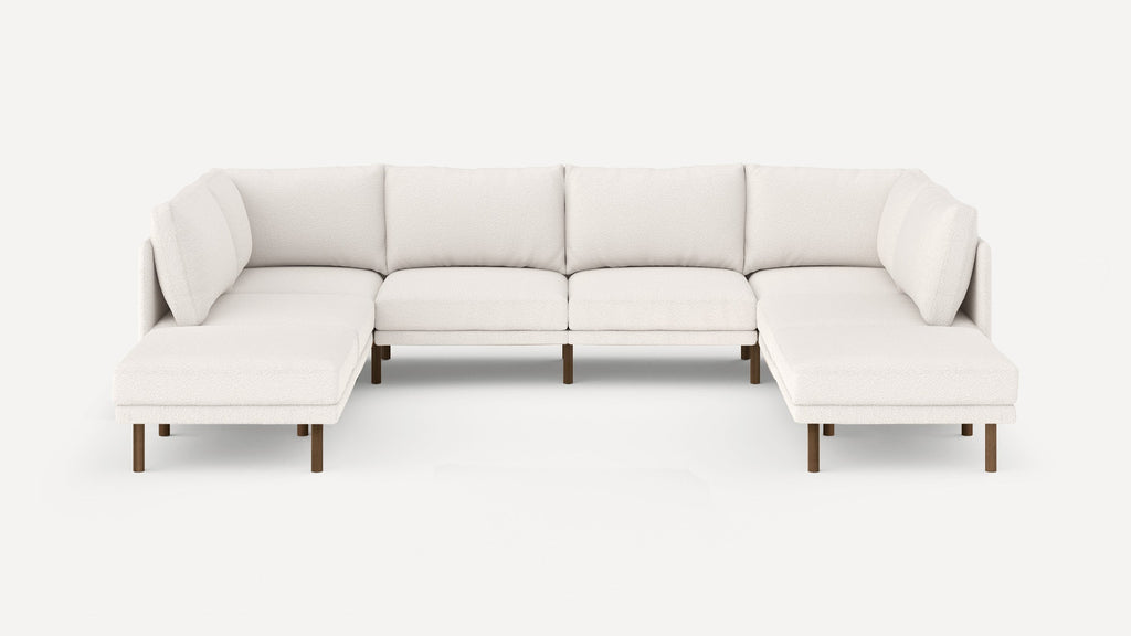 Large modern U-shaped sectional sofa in white fabric with wooden legs, featuring cushioned seats and backrests.