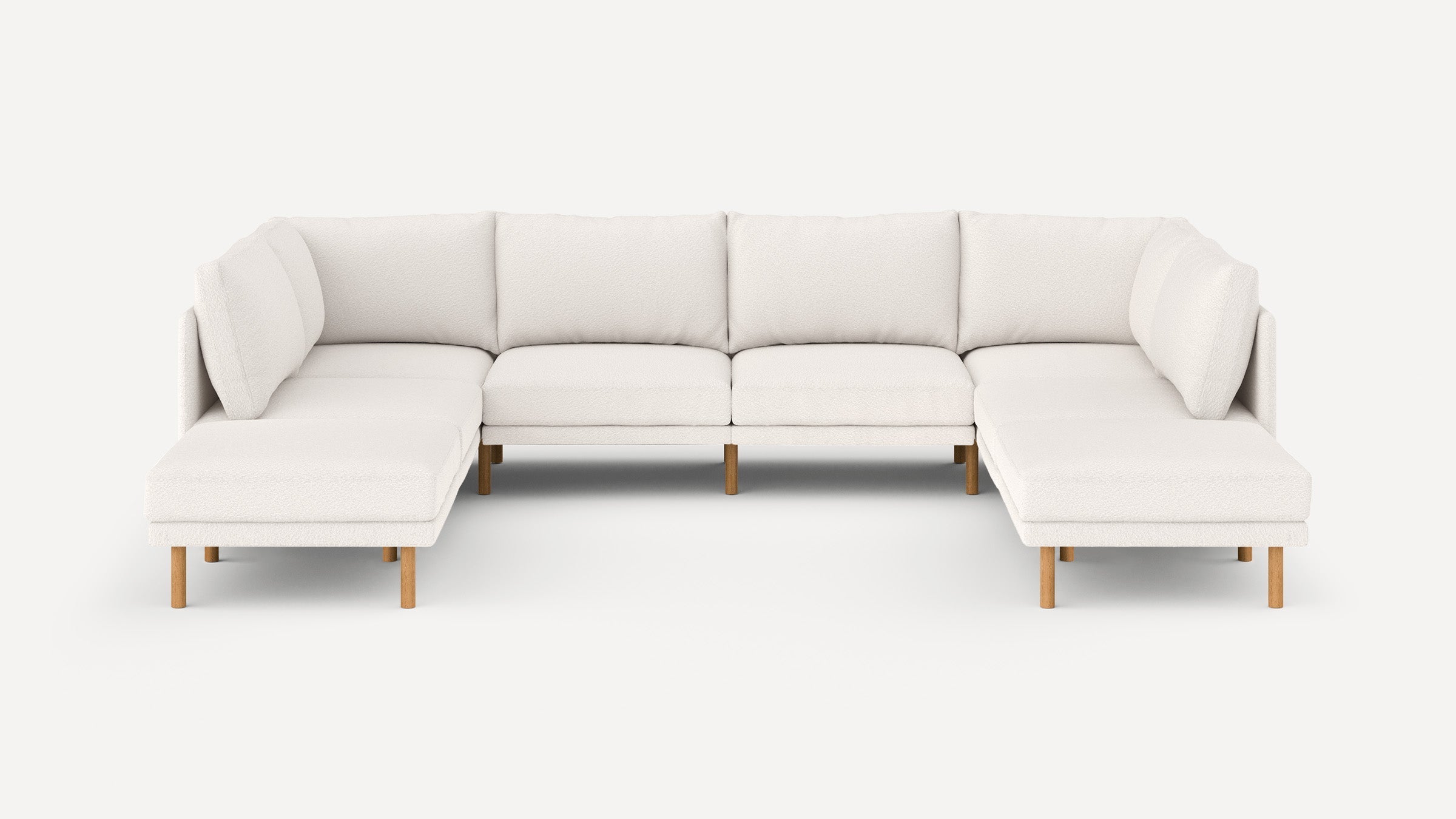 Modern U-shaped sectional sofa with soft, off-white upholstery and light wooden legs, featuring cushioned backrests and seats.