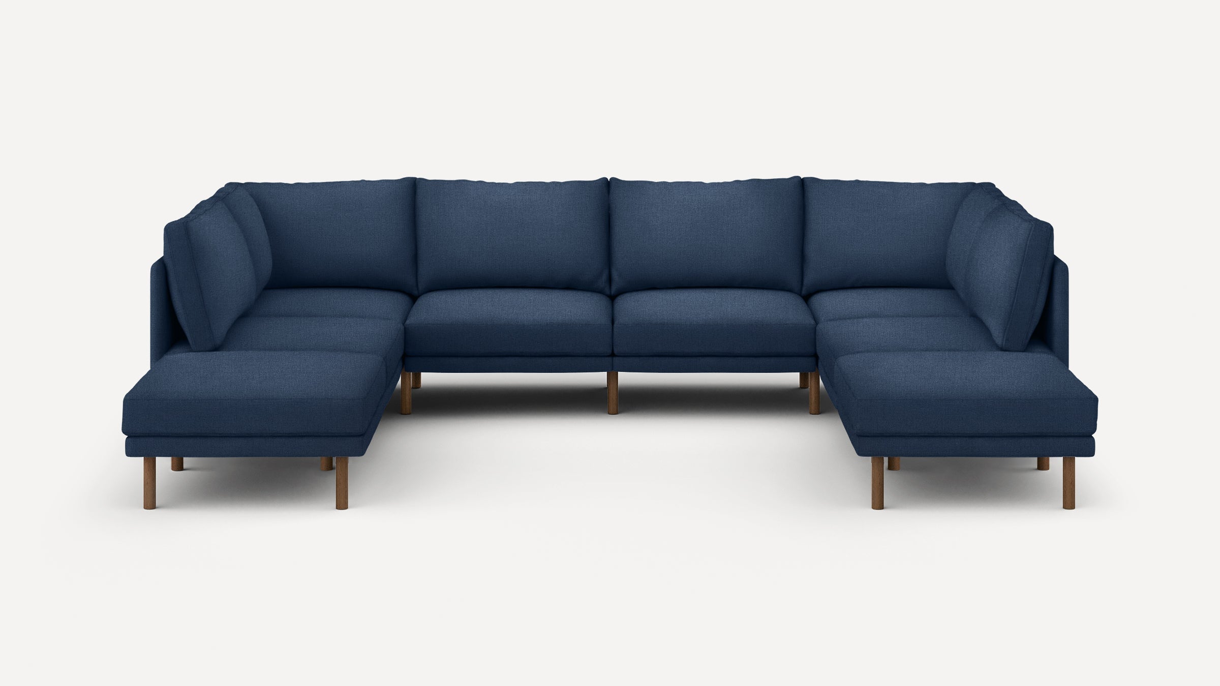 Large modern U-shaped sectional sofa with navy blue upholstery and wooden legs, featuring plush cushions and clean lines.