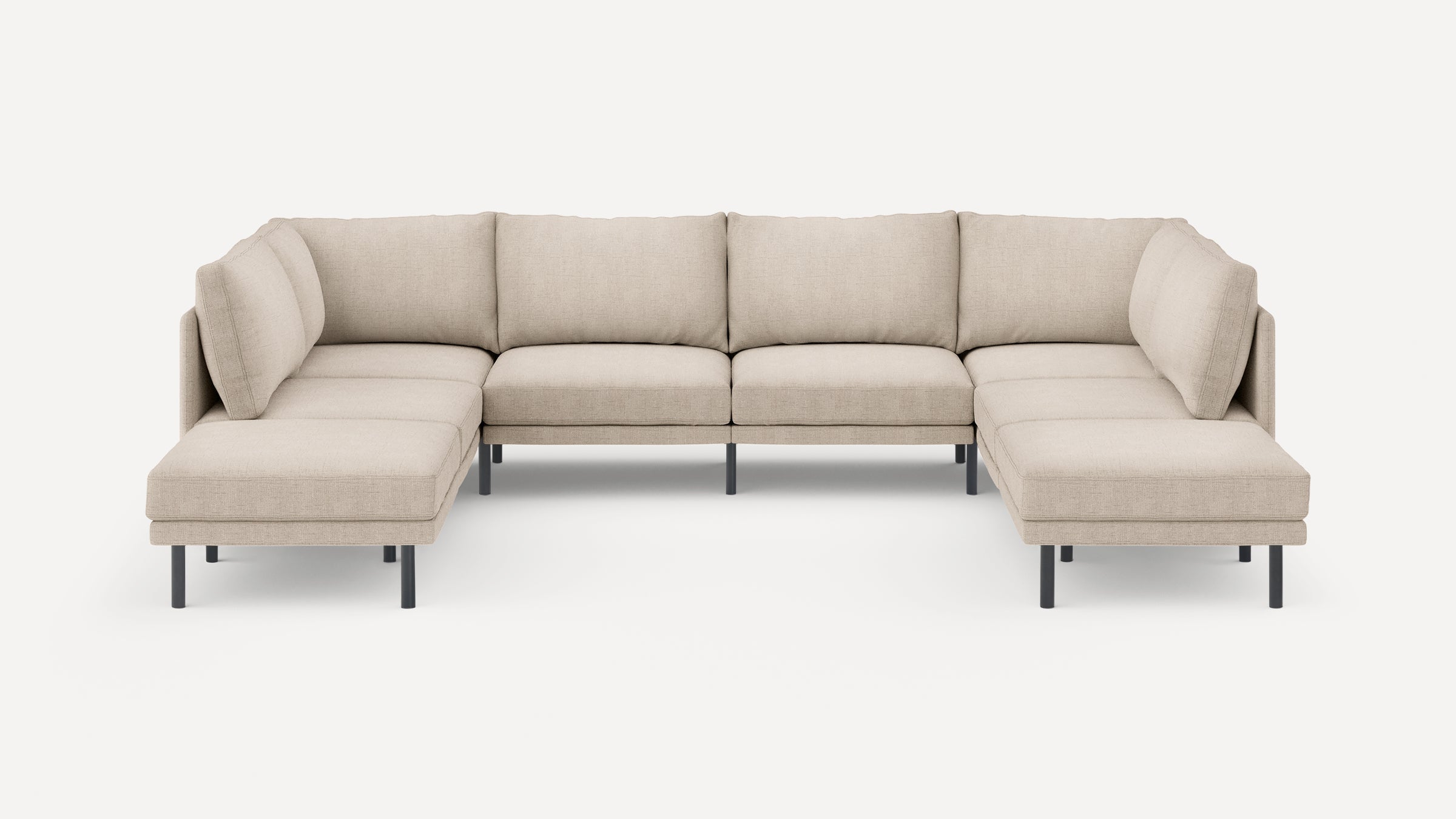 Large beige fabric sectional sofa with modern, clean lines, black metal legs, and cushioned backrests and seats.