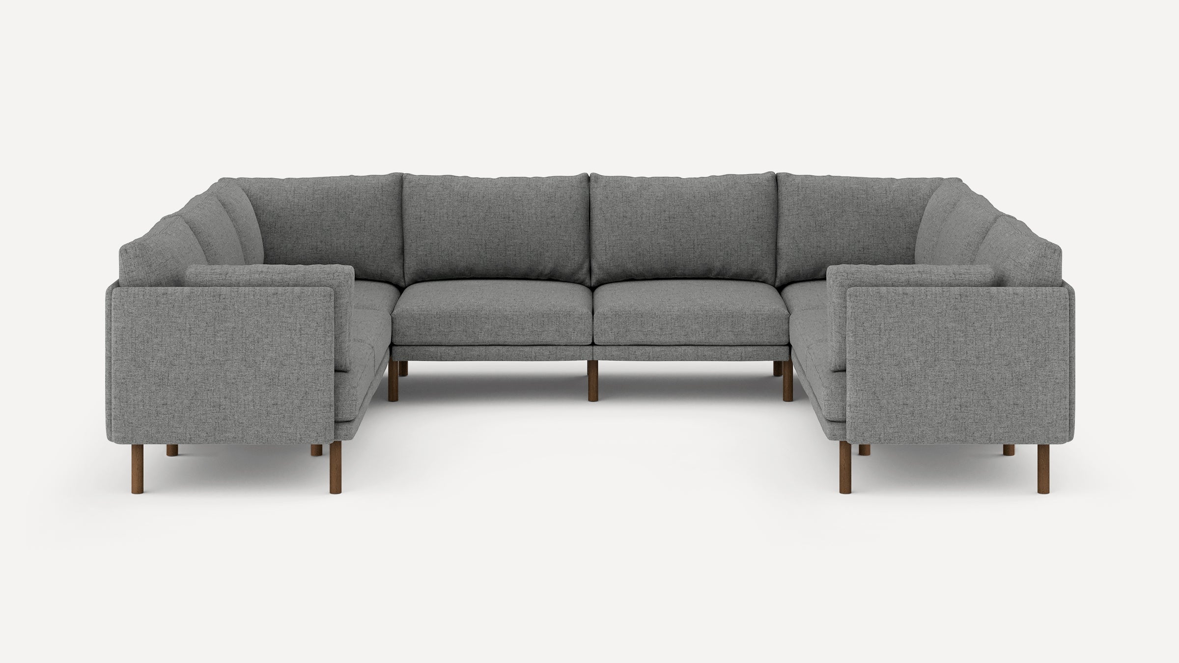 Modern U-shaped sectional sofa upholstered in grey fabric with wooden legs and plush back cushions.