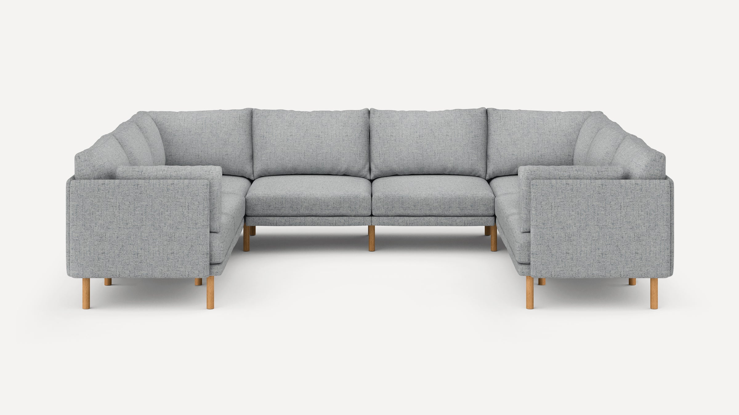 Light gray fabric U-shaped sectional sofa with wooden legs and tufted seat and back cushions.