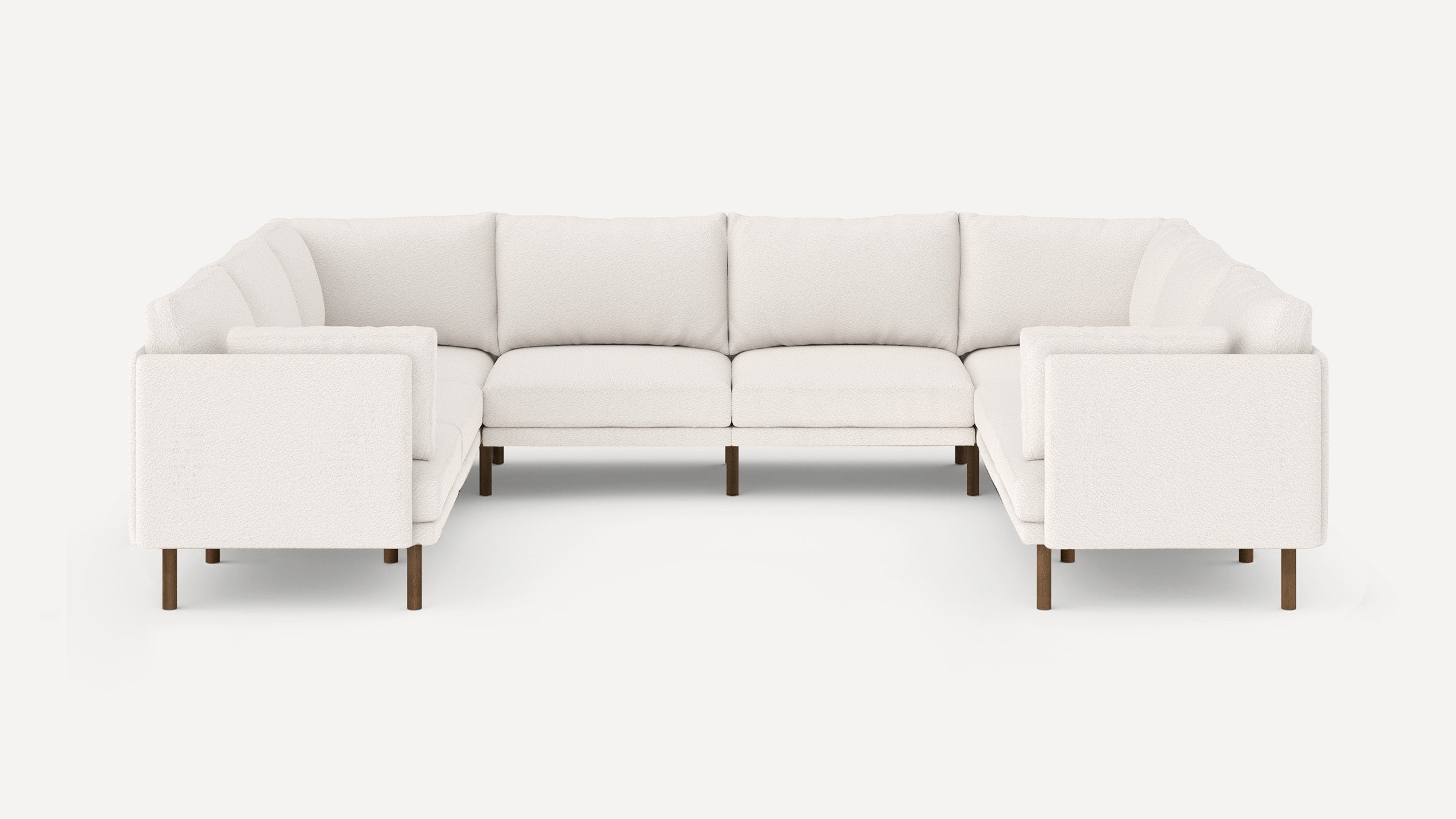 White L-shaped sectional sofa with plush cushions and dark wooden legs, set against a plain light background.