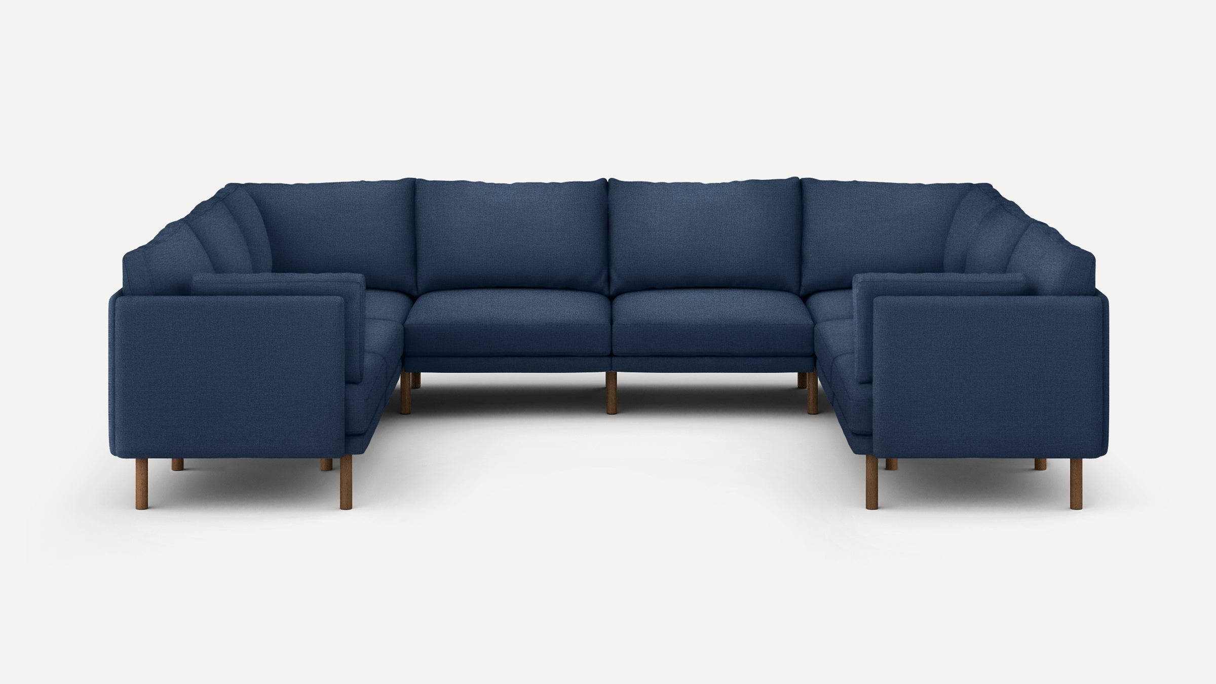 Large U-shaped sectional sofa with deep blue fabric upholstery and wooden legs, featuring clean lines and plush cushions.