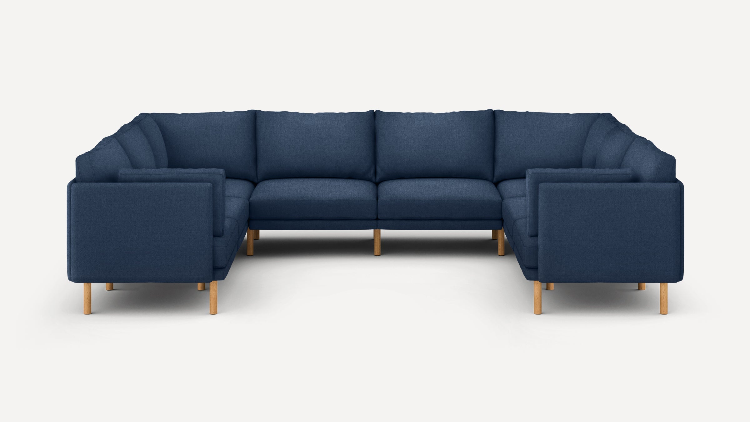 Large modern U-shaped sectional sofa with deep blue fabric upholstery and wooden legs on a white background.