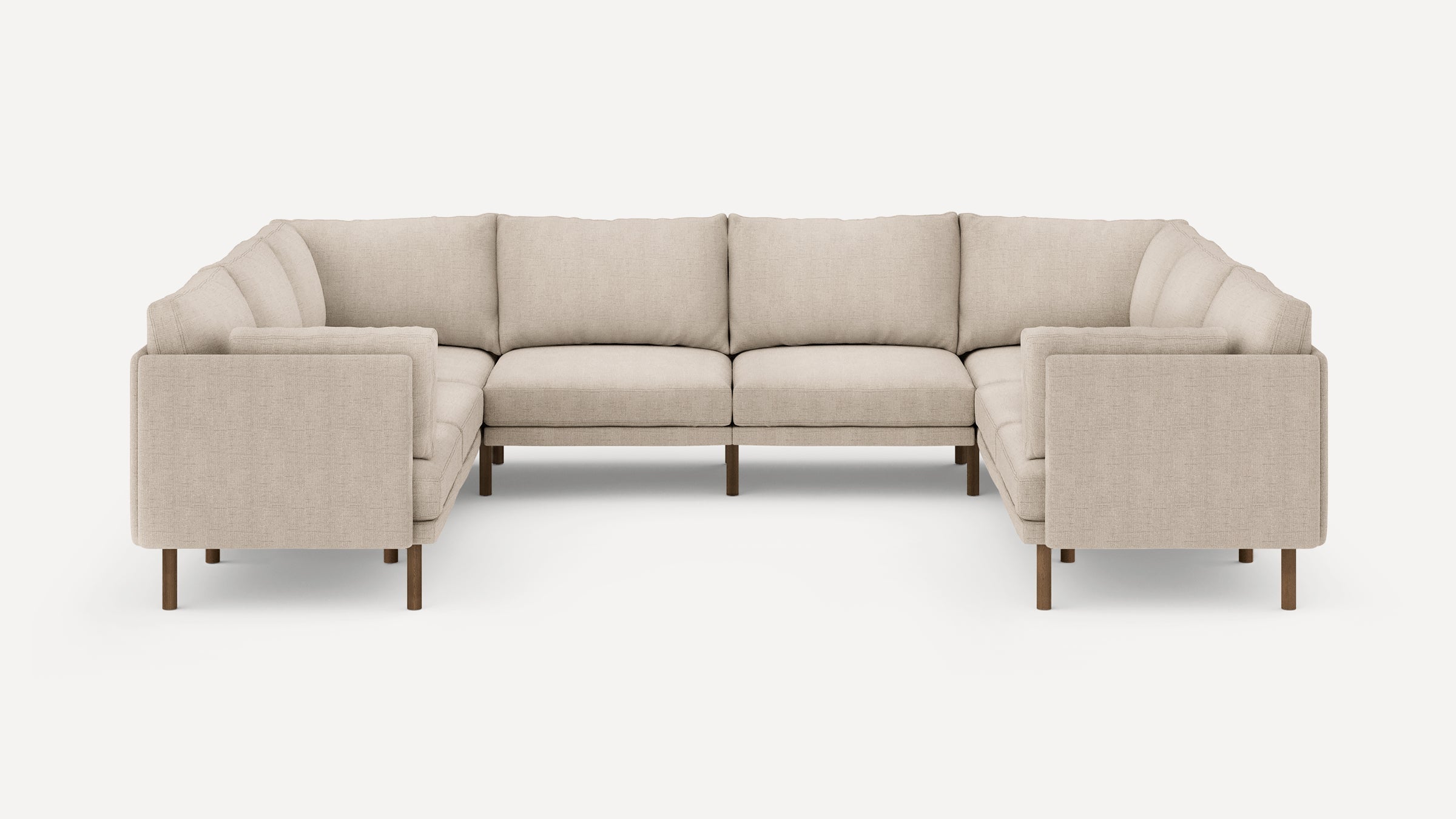 Large beige fabric sectional sofa with wooden legs, clean modern design, and plush cushions arranged in an L-shape.