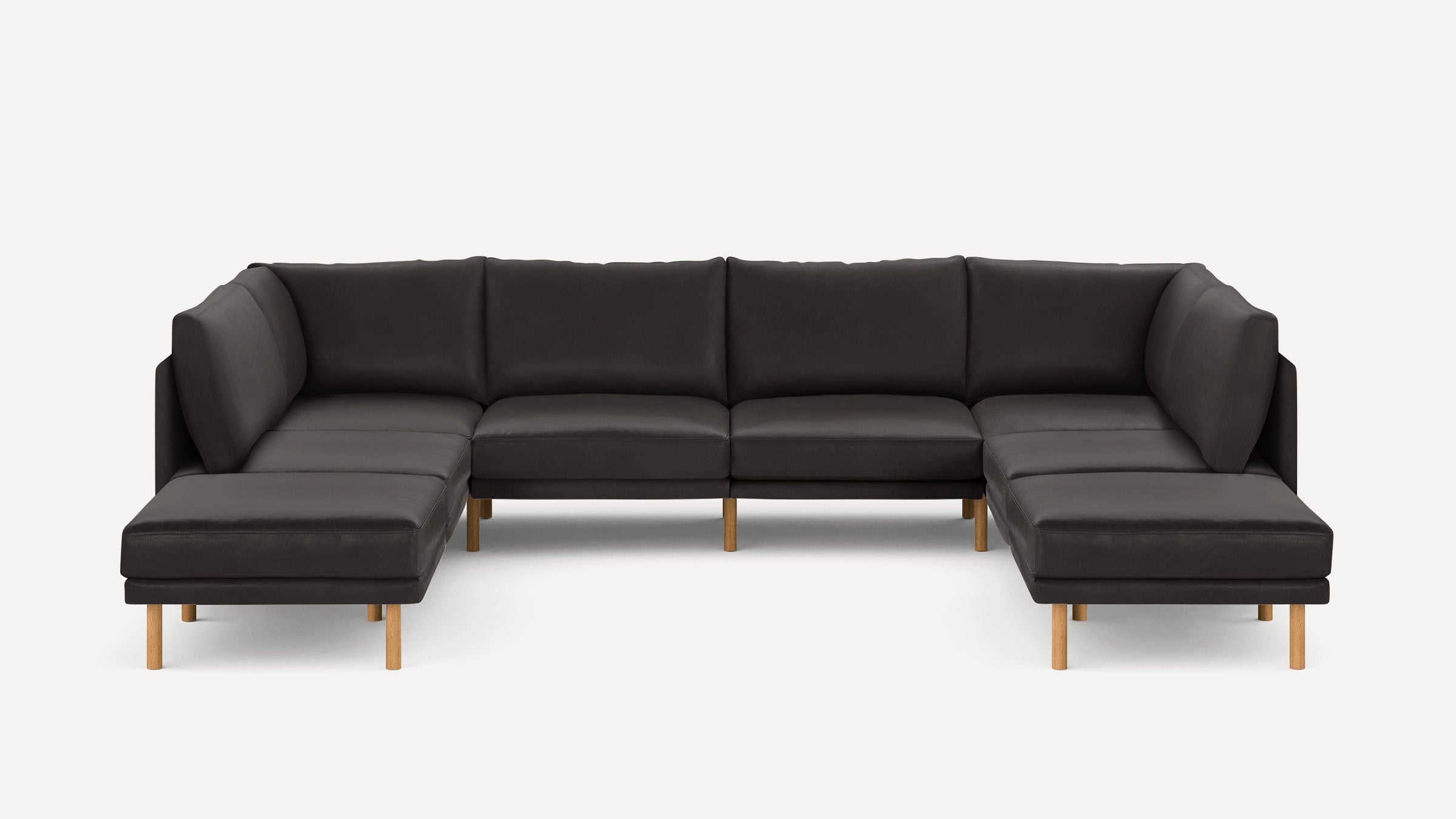 Large U-shaped sectional sofa in dark gray upholstery with light wooden legs, featuring plush cushions and clean modern design.