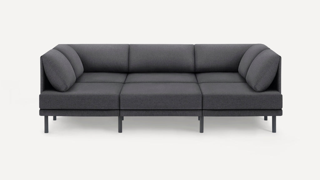 Modern dark gray three-seater sofa with cushions, straight arms, and slim black legs, set against a plain white background.