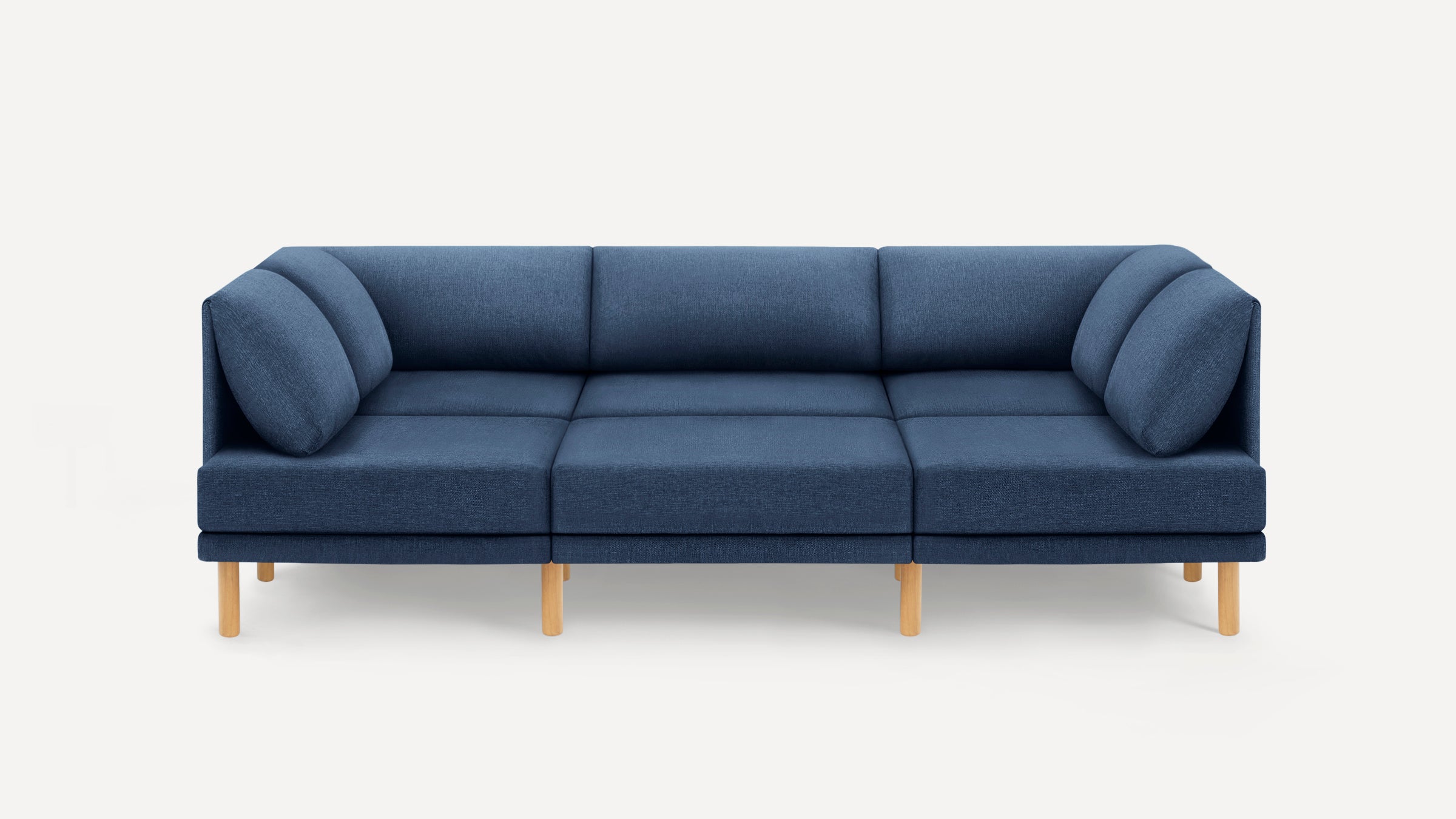 Modern three-seater sectional sofa with deep blue upholstery, cushioned back and armrests, supported by light wooden legs.