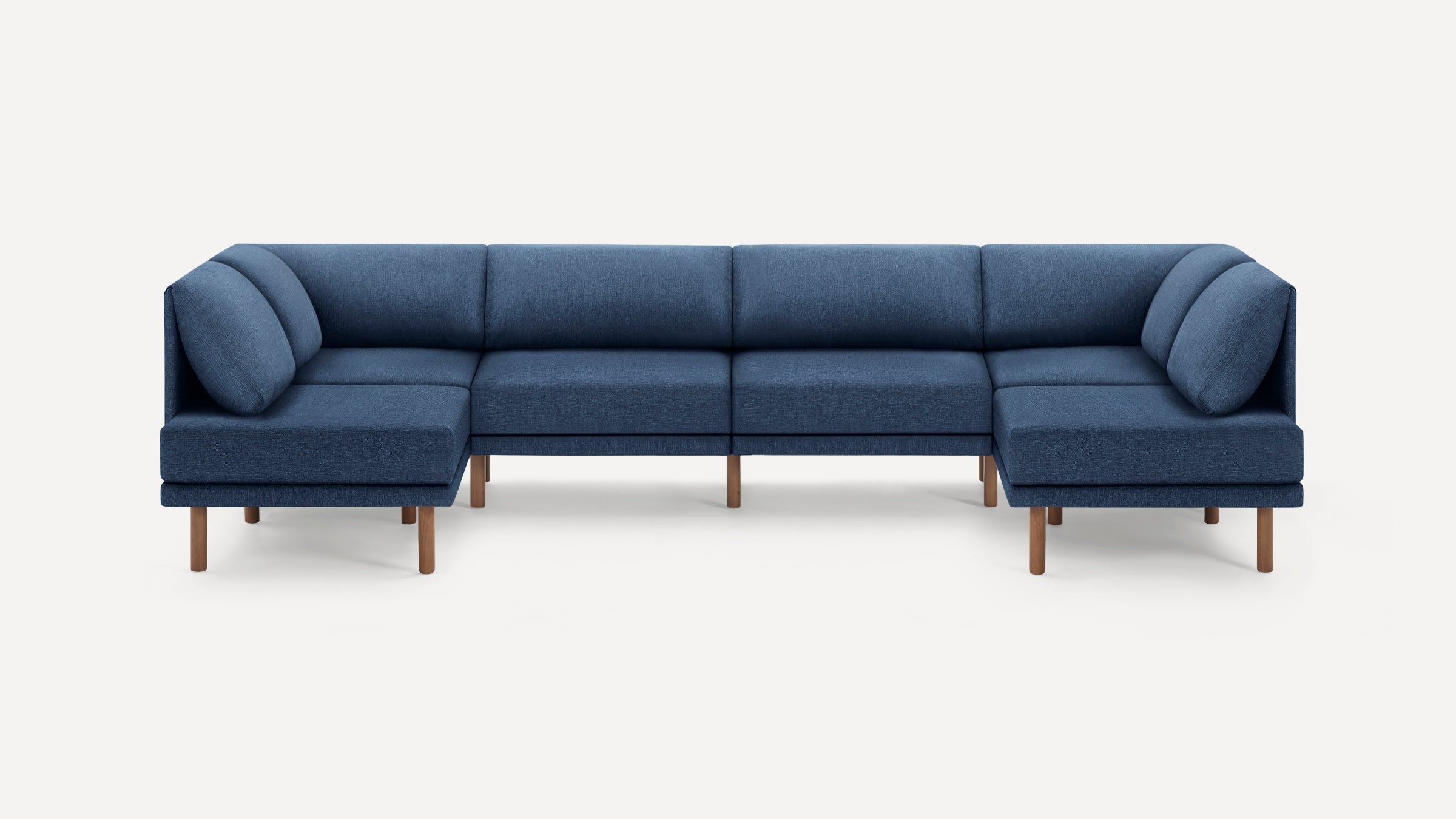 Large modern blue sectional sofa with wooden legs, featuring deep cushions and a low-profile design.