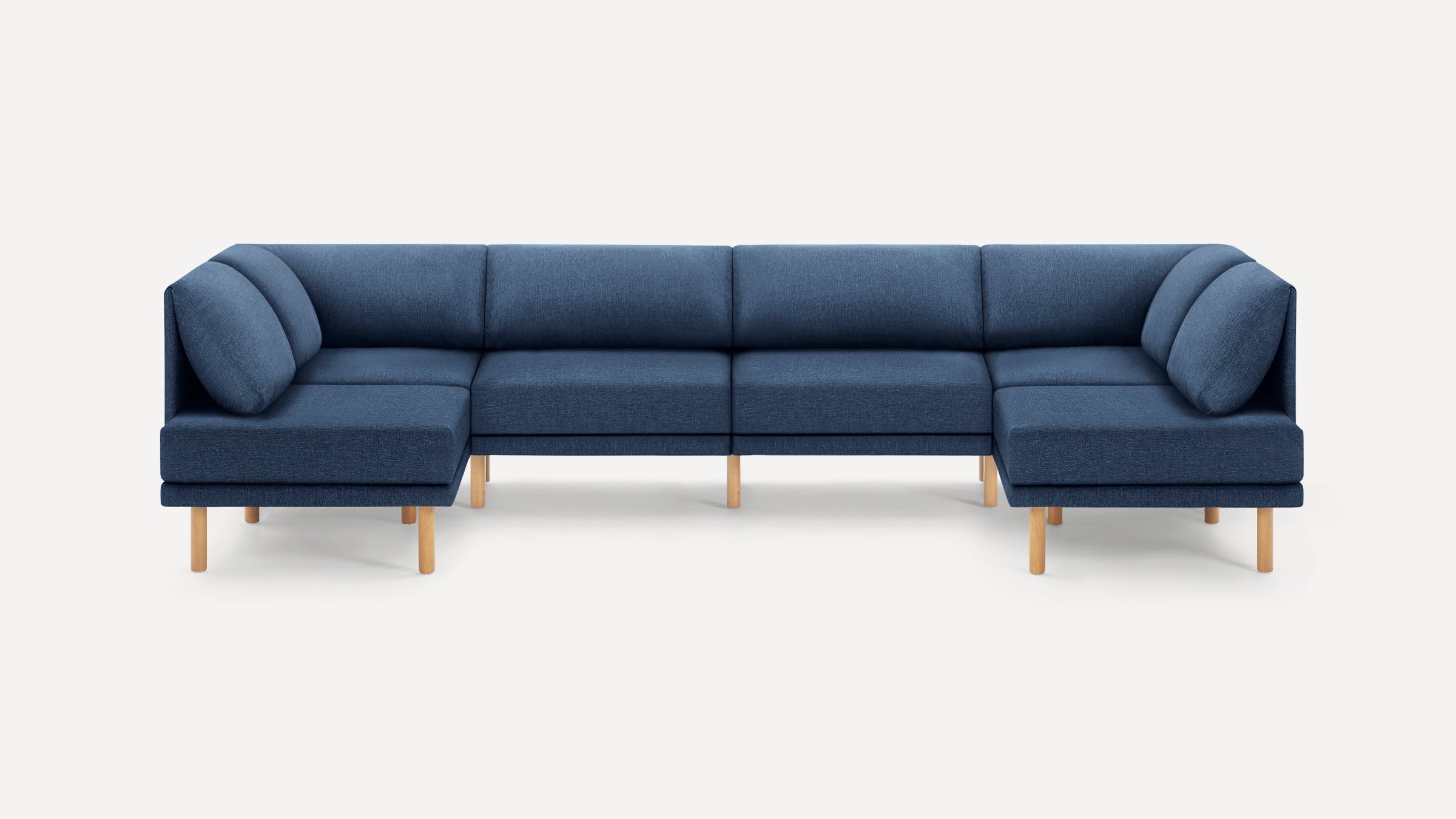 Blue fabric U-shaped sectional sofa with wooden legs, clean modern design, and plush back cushions on plain background.