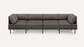 Modern, minimalist dark gray sectional sofa with four seat cushions and angled cushions on both ends, supported by slim black legs.