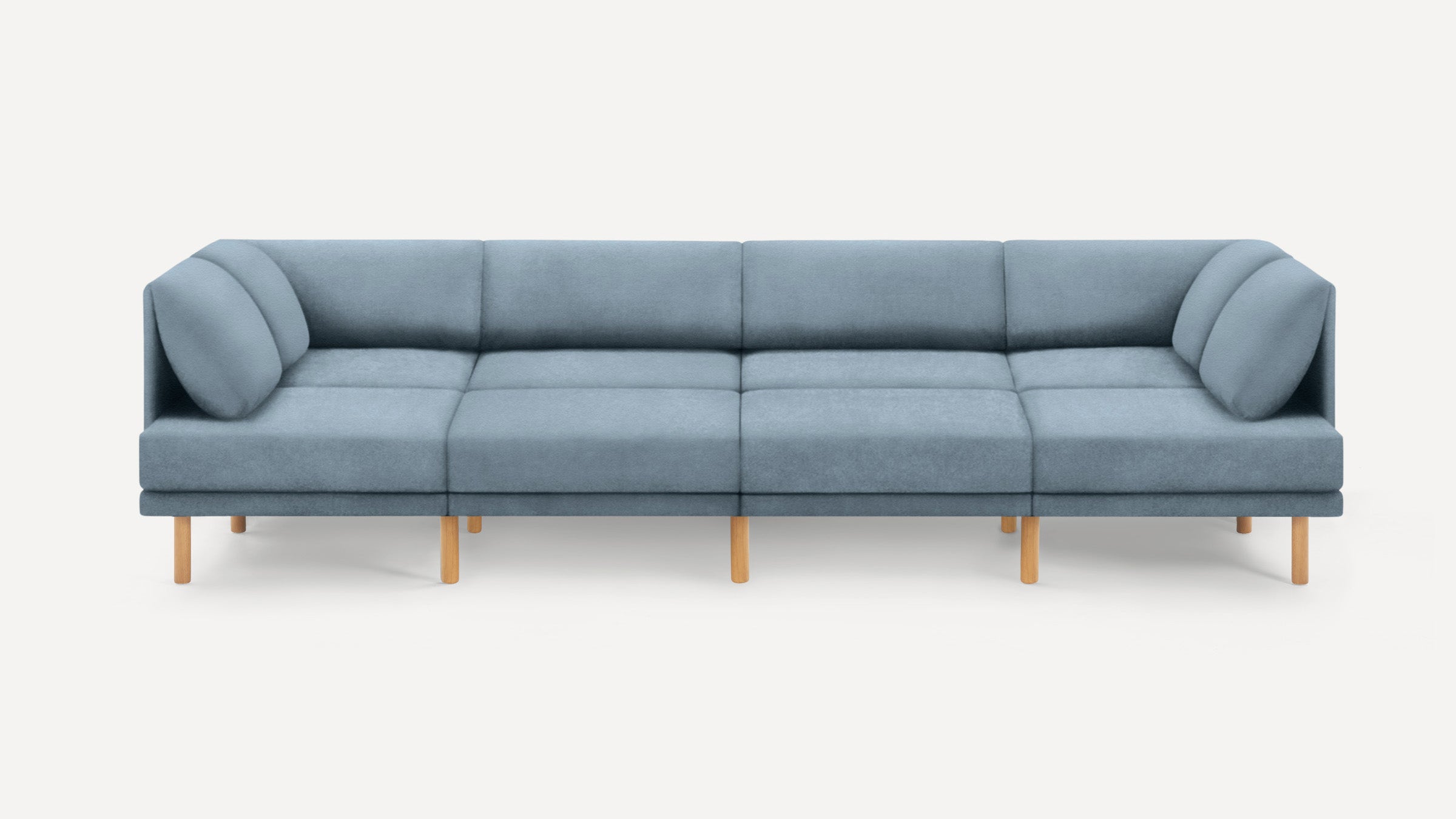 Modern sectional sofa with light blue upholstery, wooden legs, and cushioned backrests and armrests on both ends.