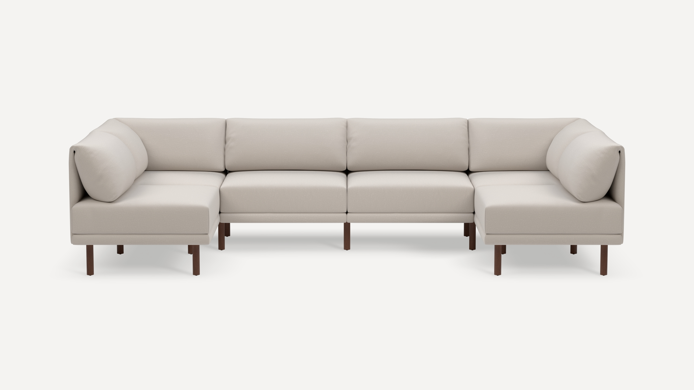 Large modern beige fabric sectional sofa with comfortable back cushions and dark wooden legs on a white background.
