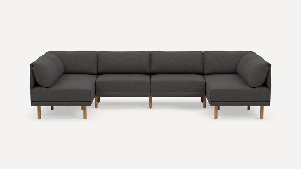 Dark gray sectional sofa with wooden legs, modern design, and cushioned back and seat for comfortable seating.