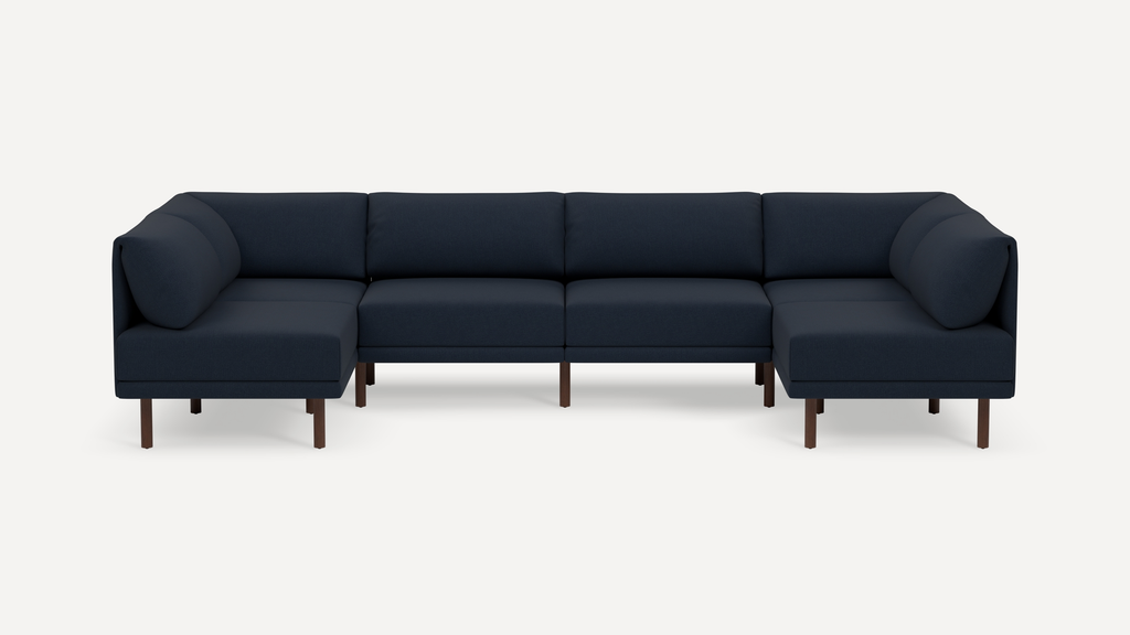 Modern navy blue sectional sofa with clean lines, plush cushions, and wooden legs, designed for spacious seating in a minimalist style.