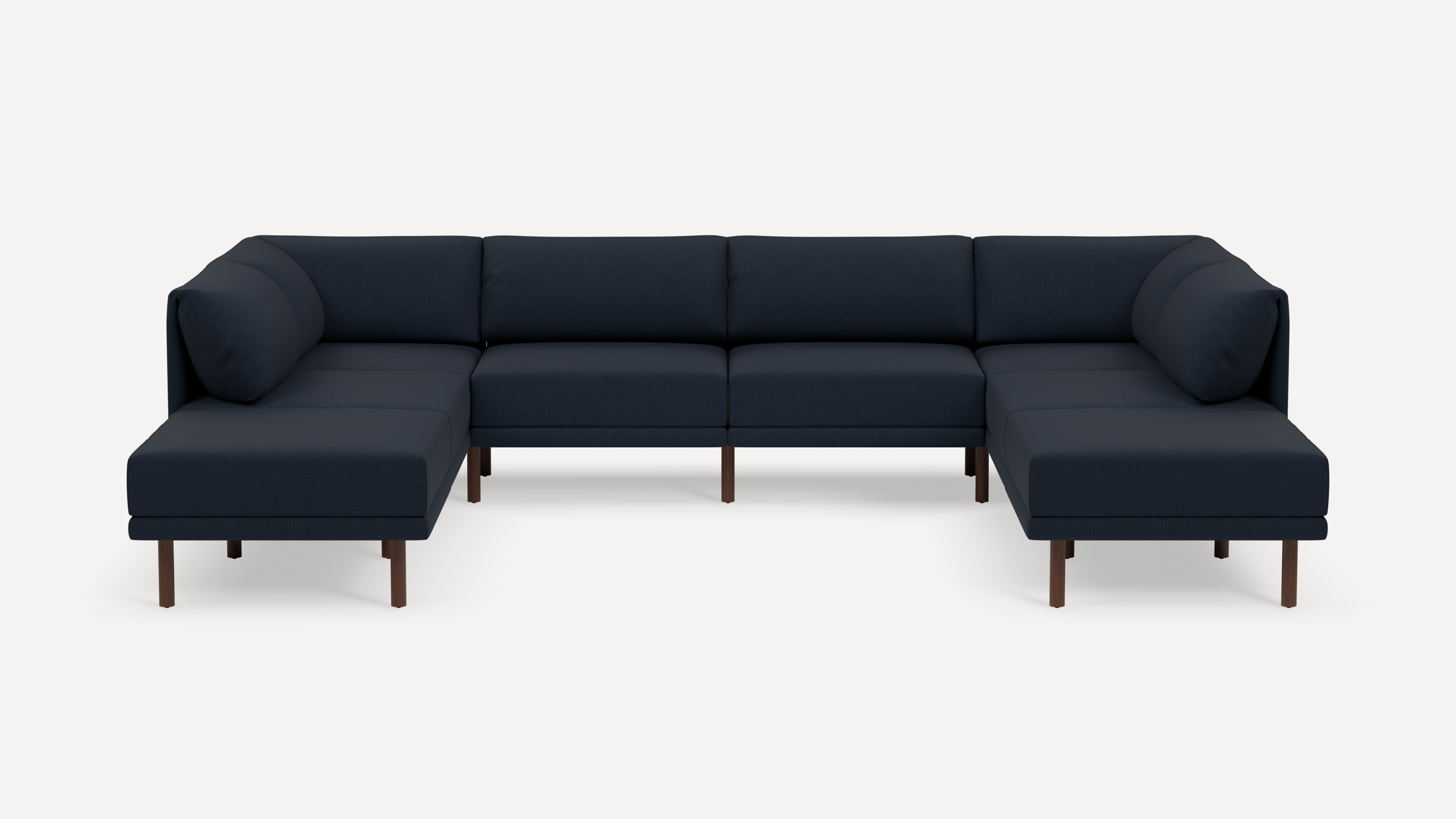 Large modern navy blue sectional sofa with wooden legs and cushioned backrests isolated on white background.