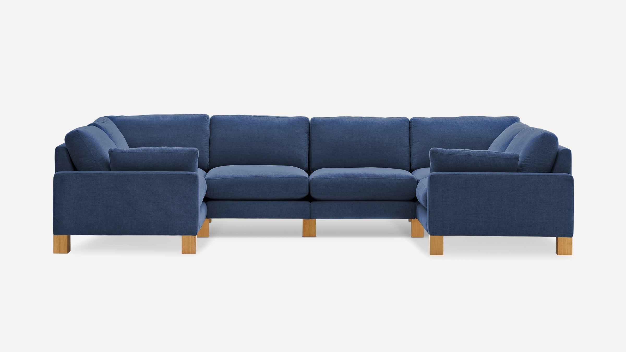Large blue sectional sofa with wooden legs, featuring cushioned seats, backrests, and armrests in a modern design.