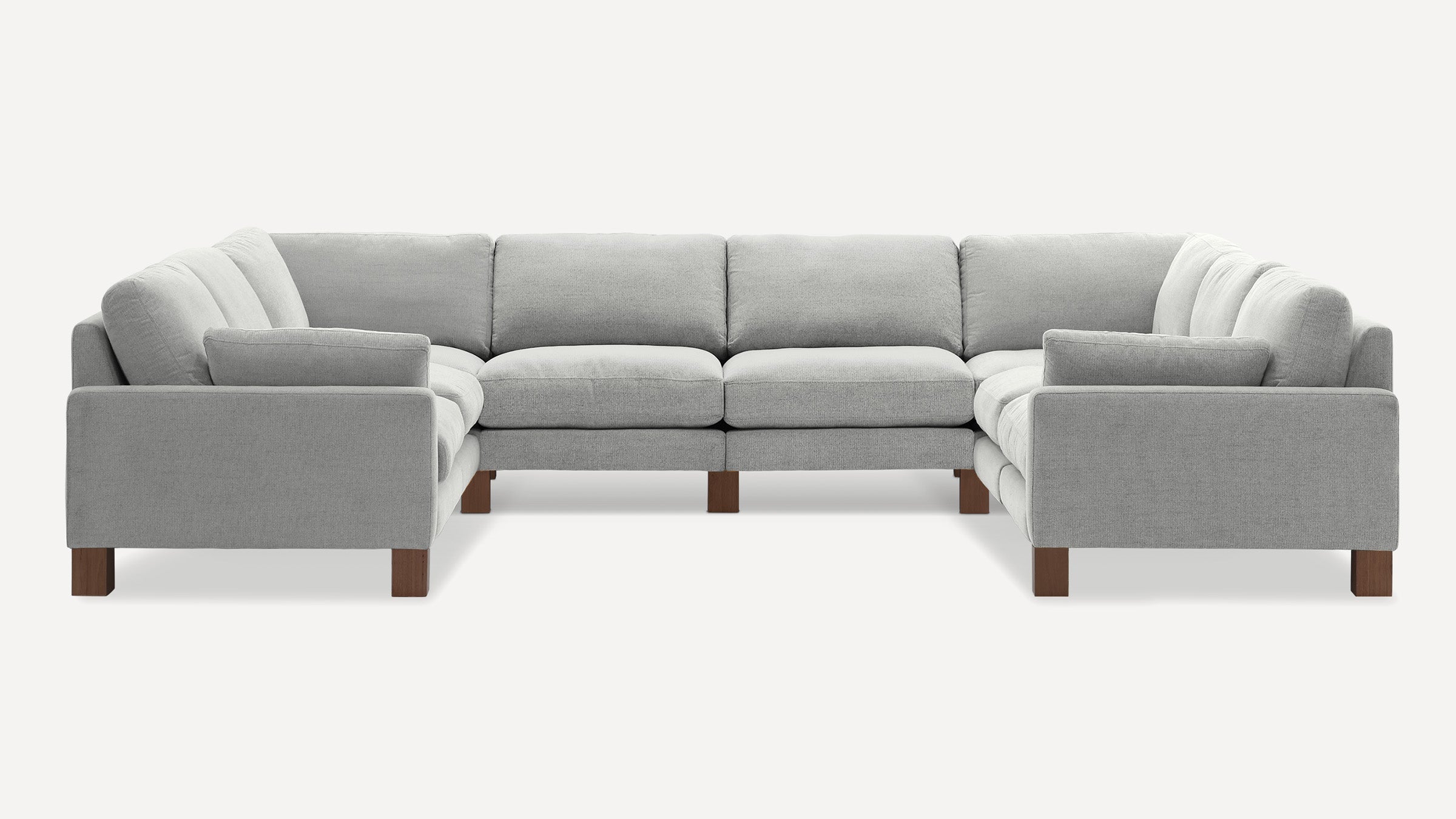 Light gray L-shaped sectional sofa with soft cushions and wooden block legs, designed for spacious seating.