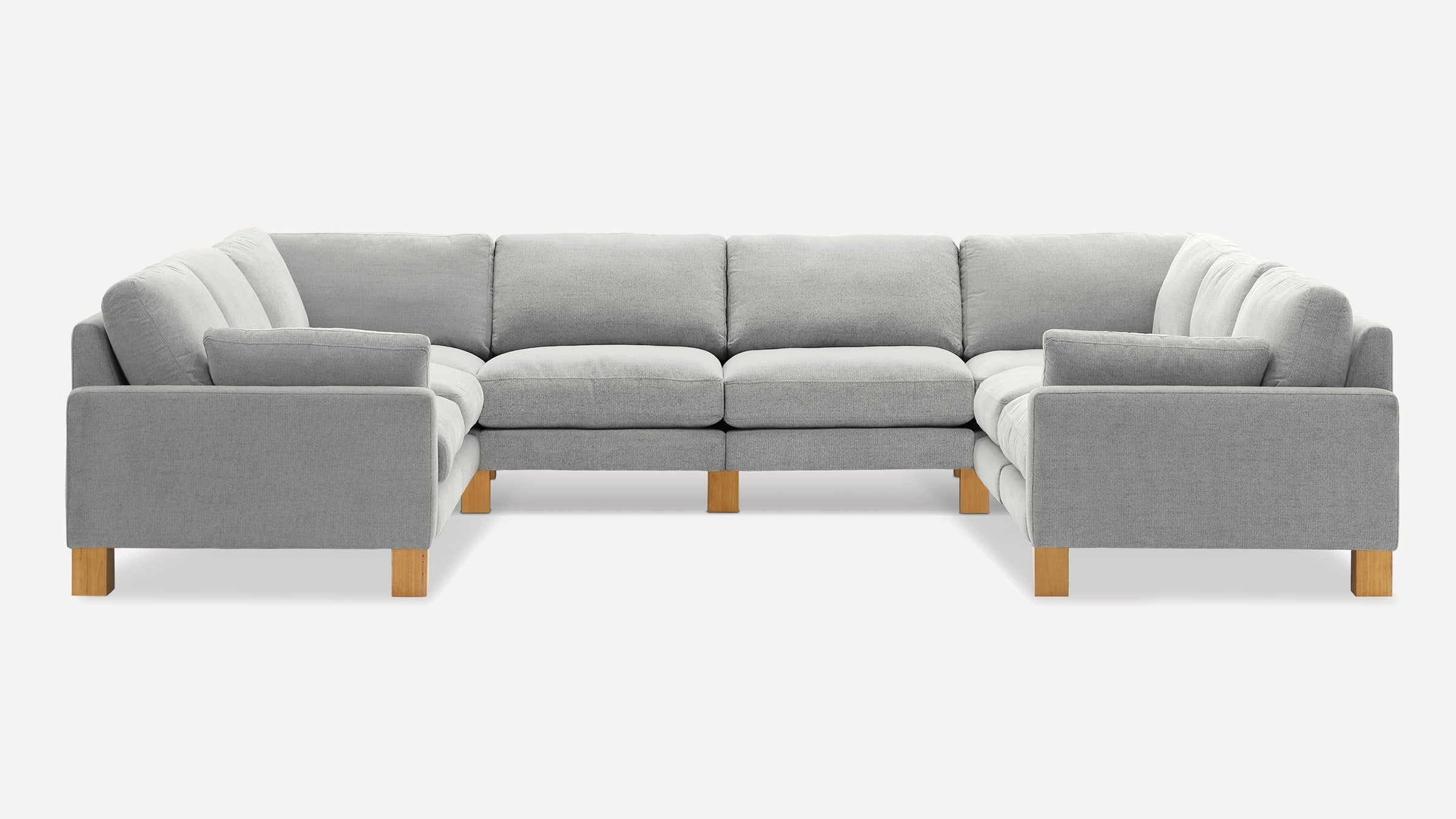 U-shaped sectional sofa with light gray fabric upholstery and natural wood block legs, featuring plush cushions and padded armrests.
