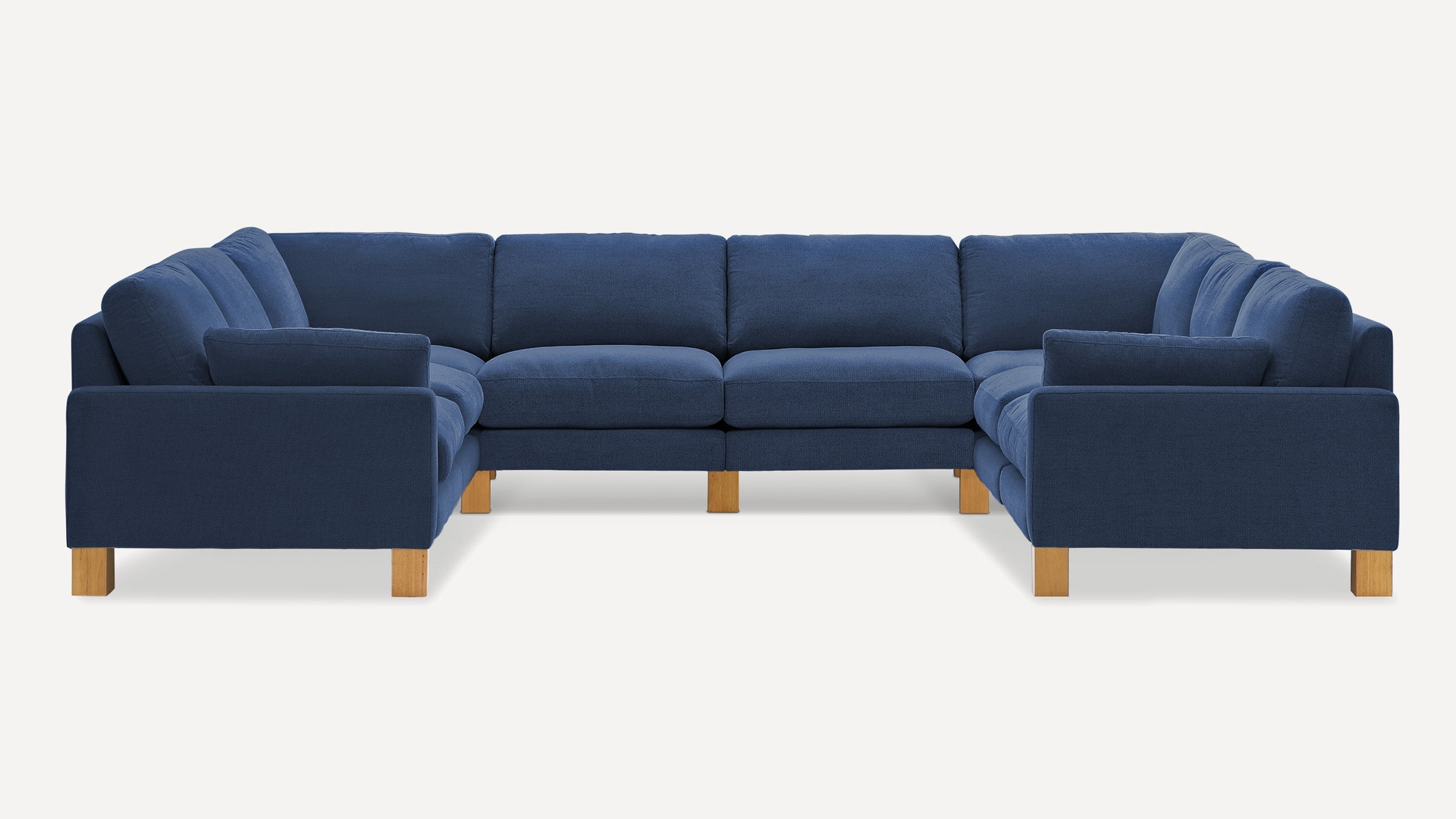 Large U-shaped sectional sofa in deep navy blue fabric with wooden block legs and cushioned seats and backs.