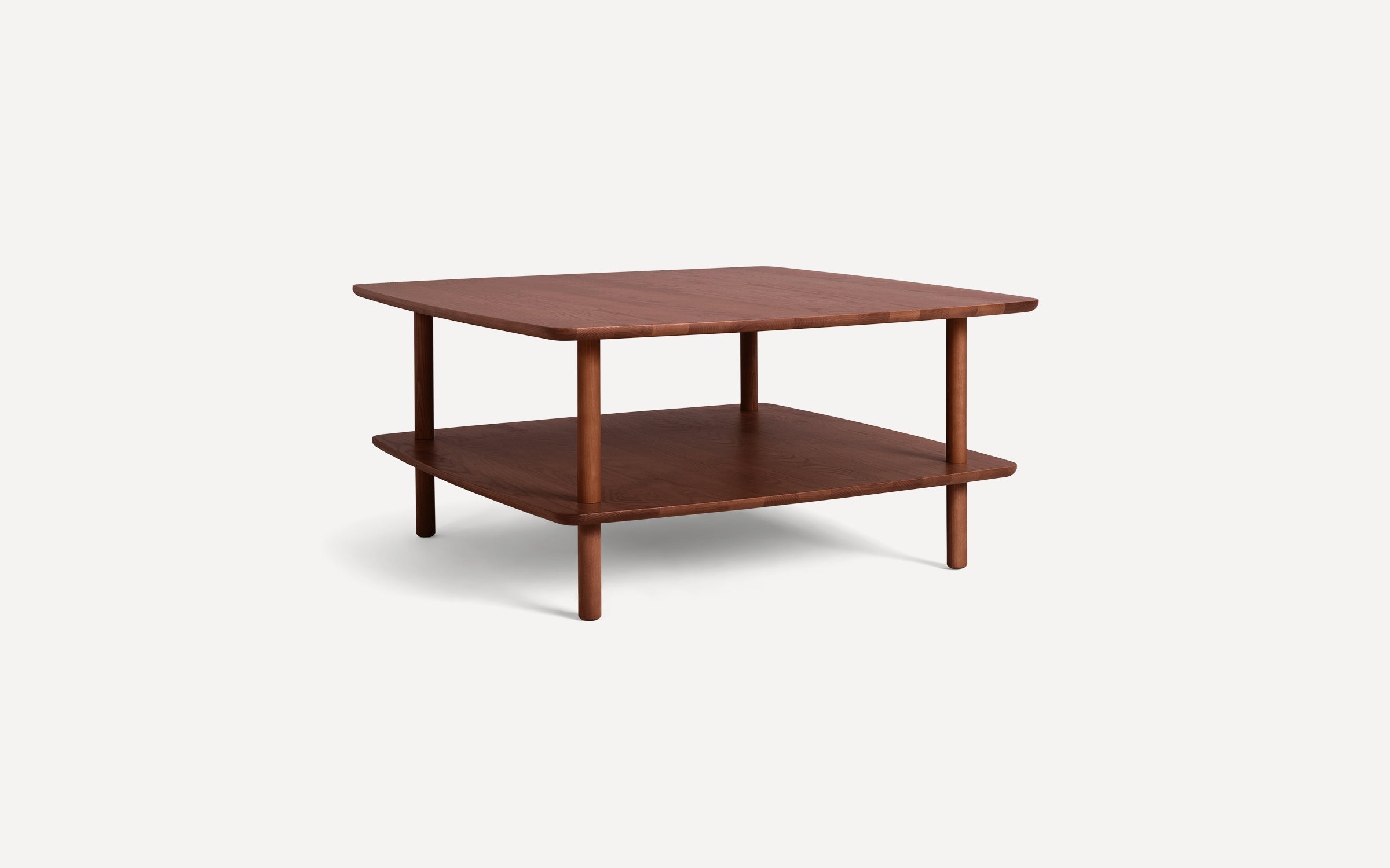 Square wooden two-tier coffee table with rounded edges and four cylindrical legs, showcasing a smooth, dark walnut finish.