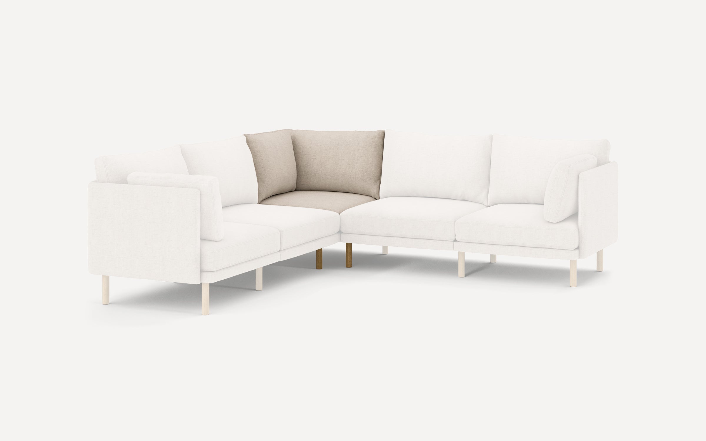 Modern L-shaped sectional sofa with light beige and white cushions, supported by slender wooden legs, minimalist design.