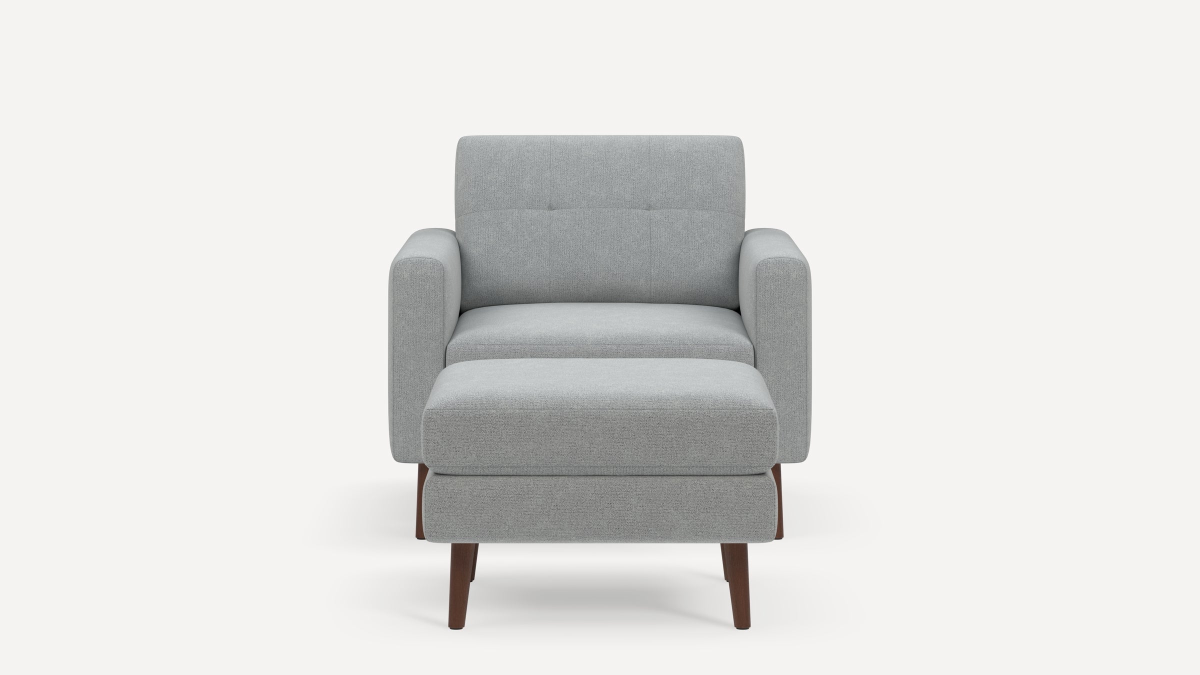 Front view of a modern light gray upholstered armchair with a matching ottoman and wooden legs on a white background.