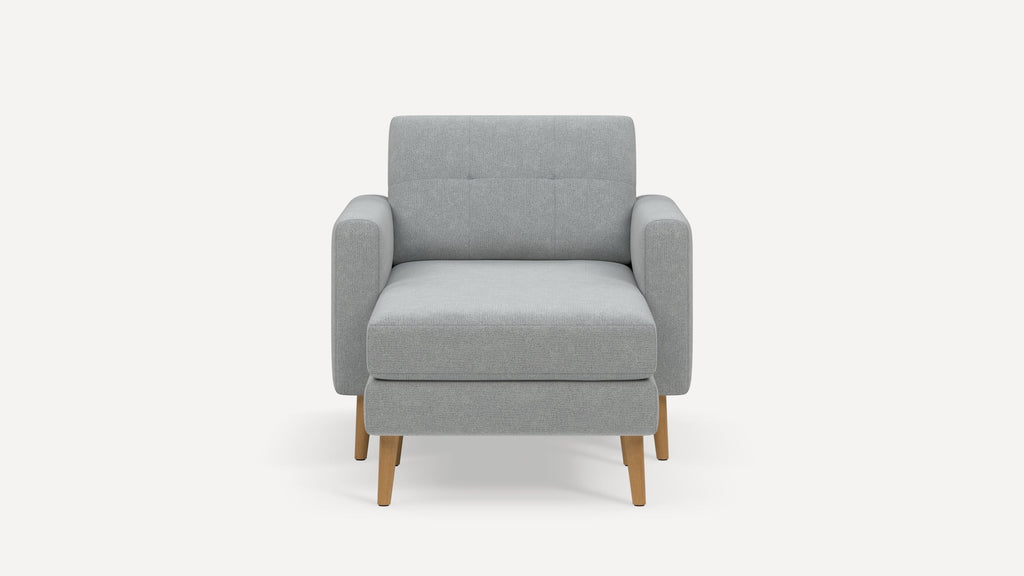 Modern light grey fabric armchair with clean lines, wooden tapered legs, and cushioned seat and backrest.