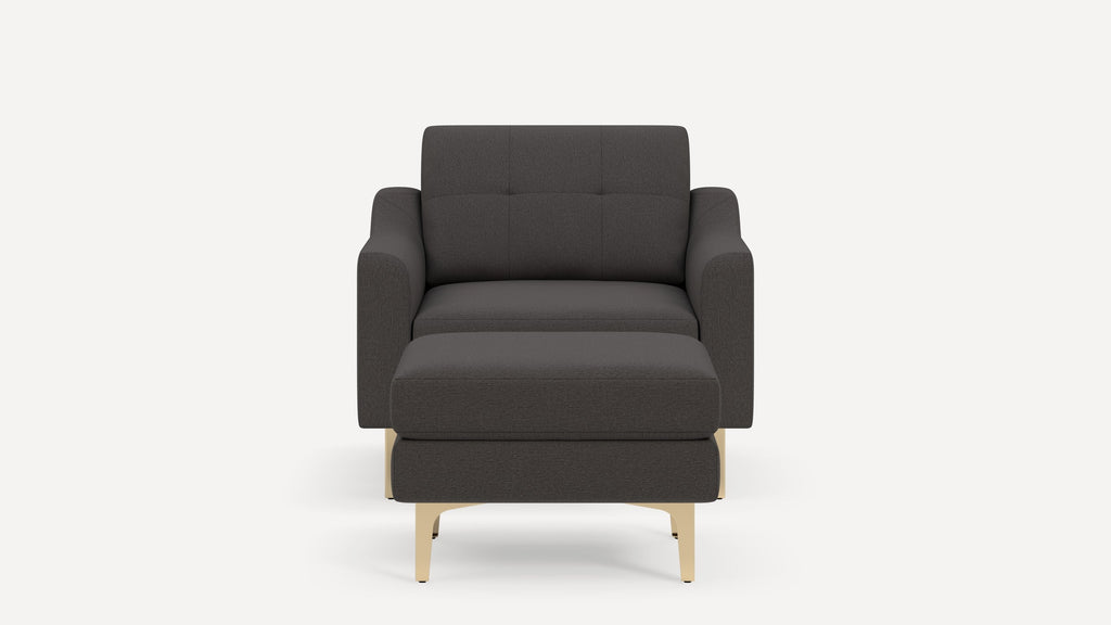 Front view of a dark gray modern armchair with a matching ottoman and light wooden legs on a plain white background.