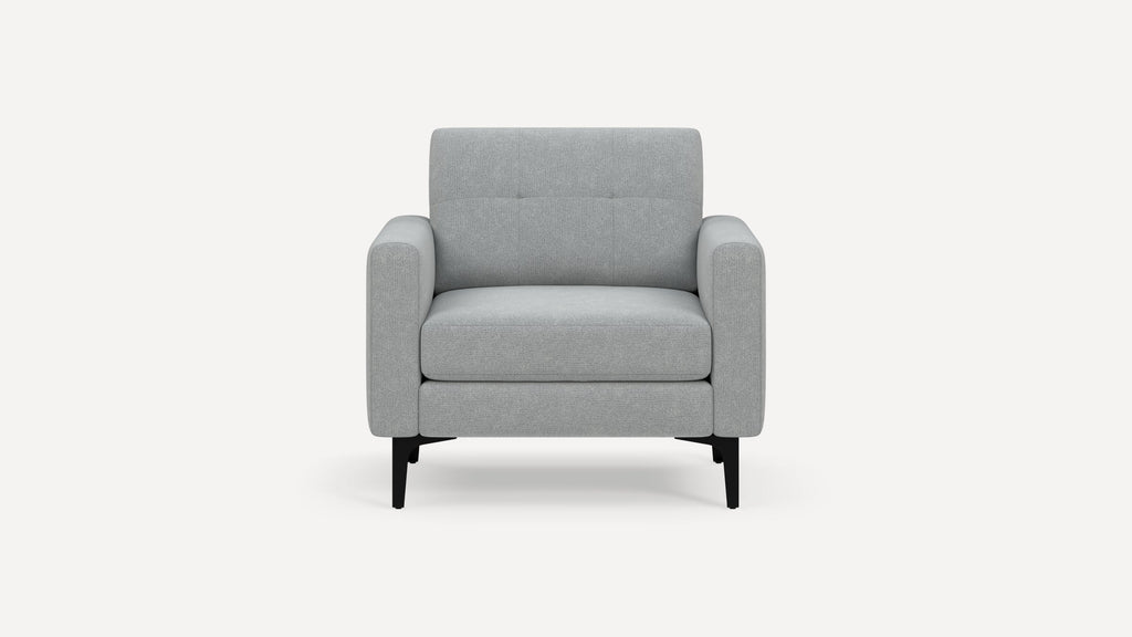 Modern light gray upholstered armchair with wide arms, tufted backrest, and black metal legs, shown against a white background.