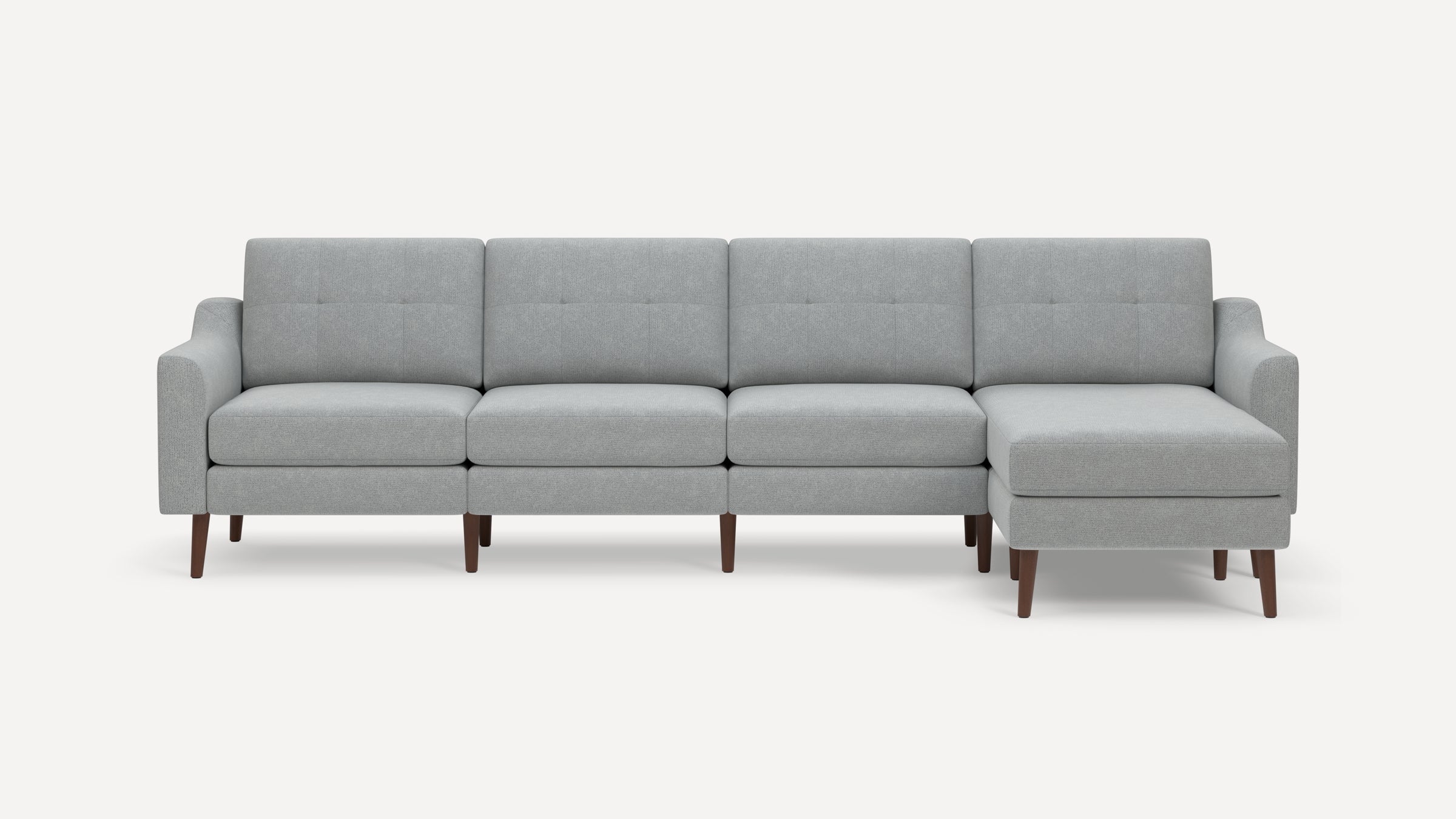 Modern light gray sectional sofa with tufted back cushions, wooden legs, and a right-side chaise lounge.