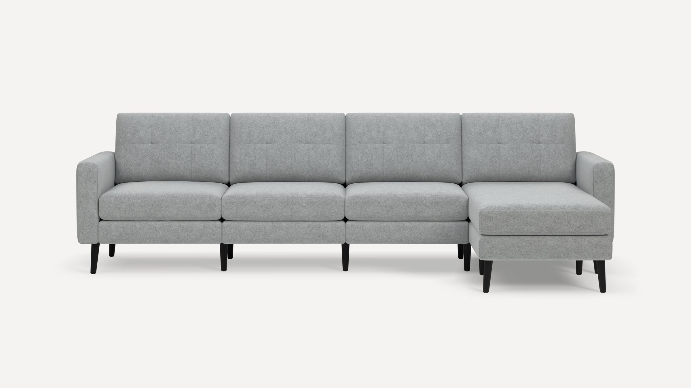 Light gray modern sectional sofa with tufted back cushions, straight armrests, and black tapered legs on a white background.