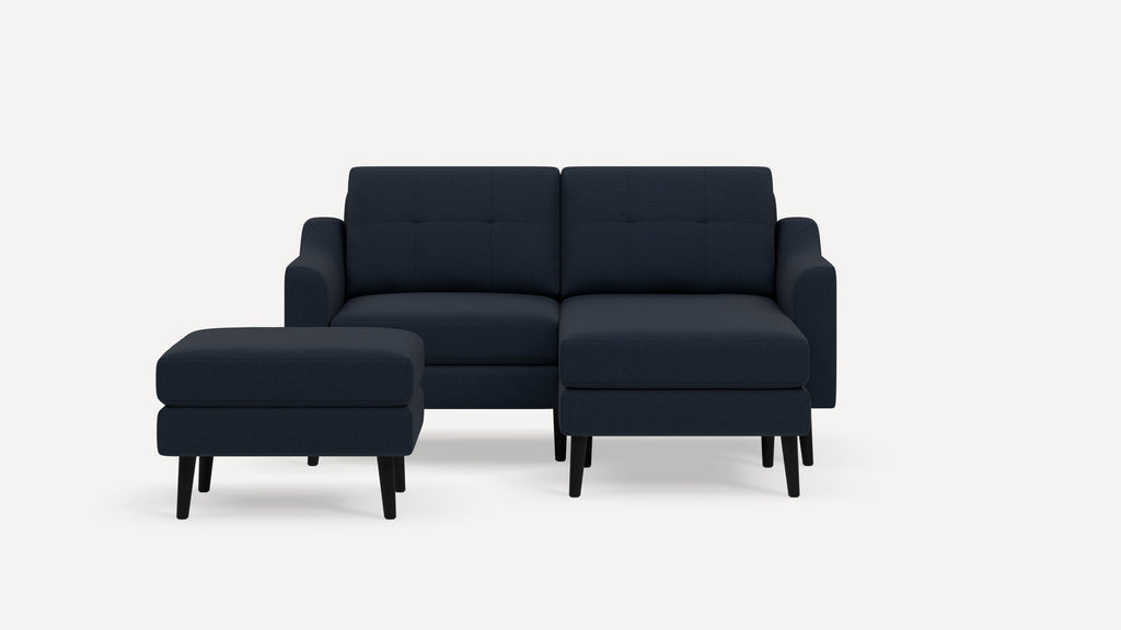 Dark navy blue mid-century modern sofa set with two cushioned ottomans, clean lines, tufted backrests, and black wooden legs.