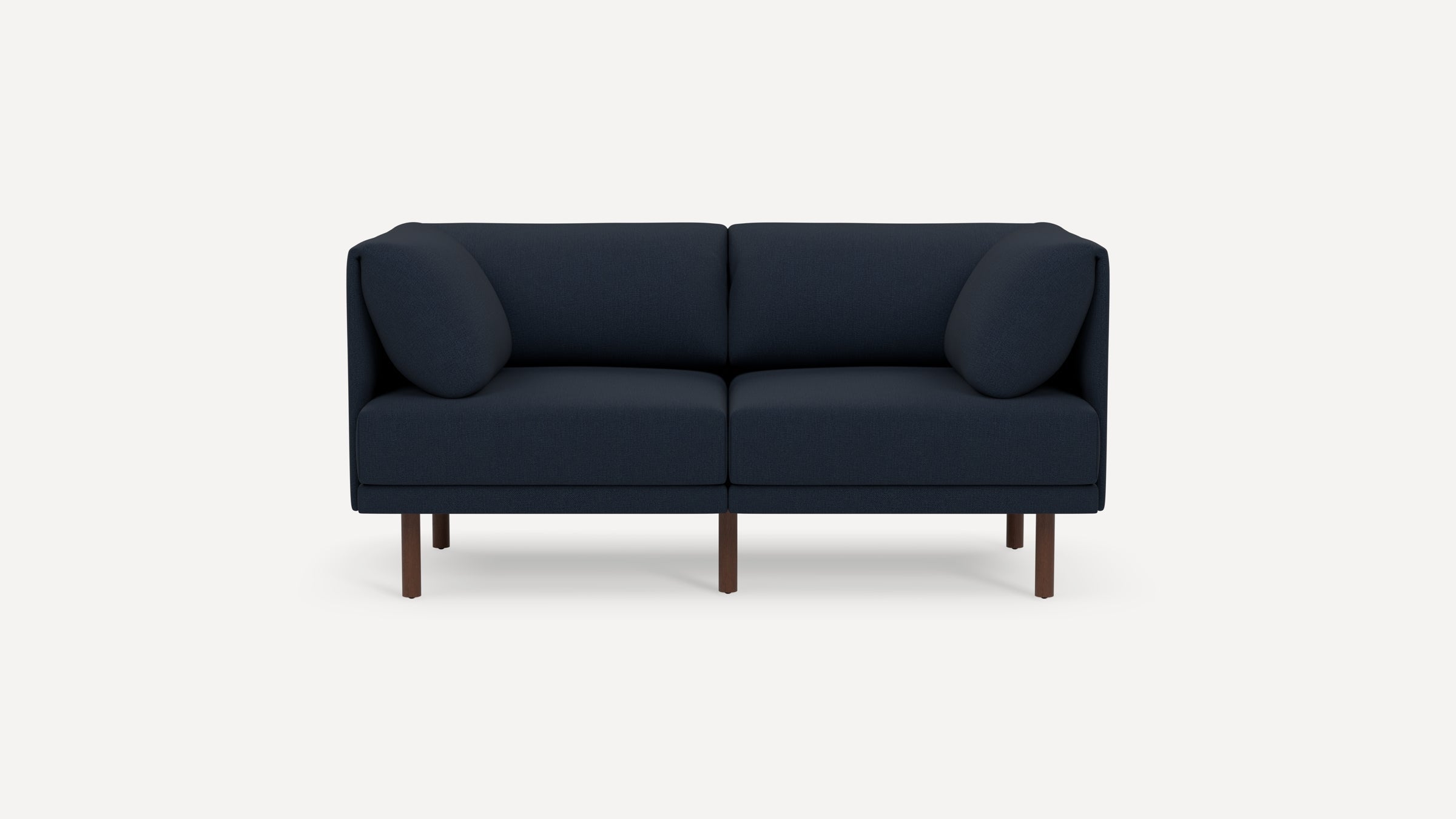 Modern navy blue two-seater sofa with rounded arm cushions and slim wooden legs on a white background.