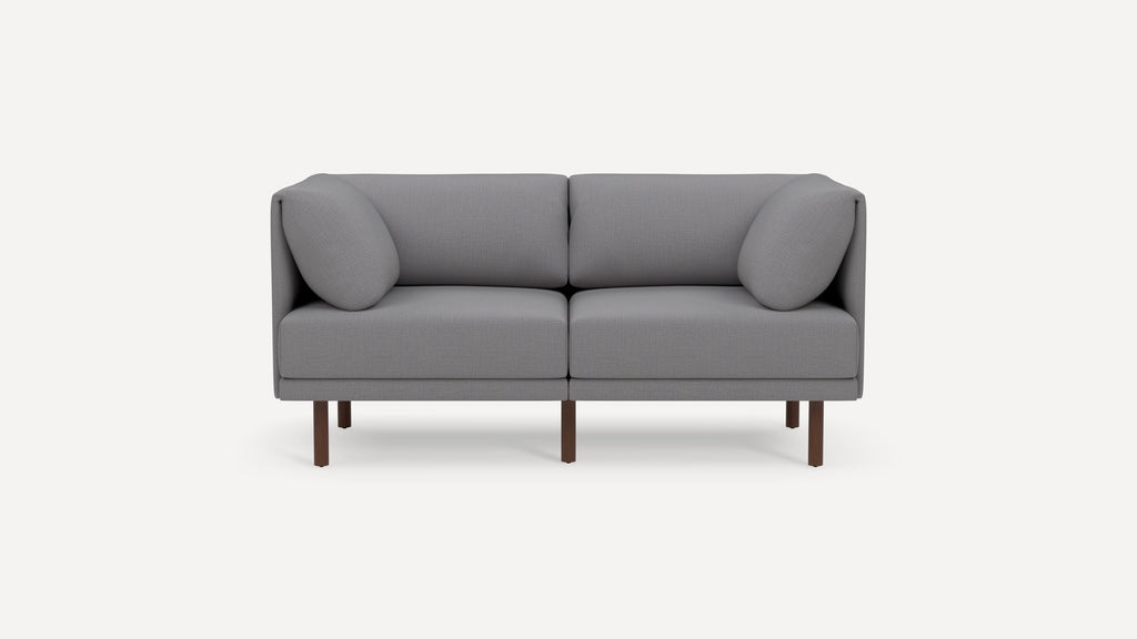 Modern gray two-seater sofa with clean lines, square cushions, and dark wooden legs, set against a white background.