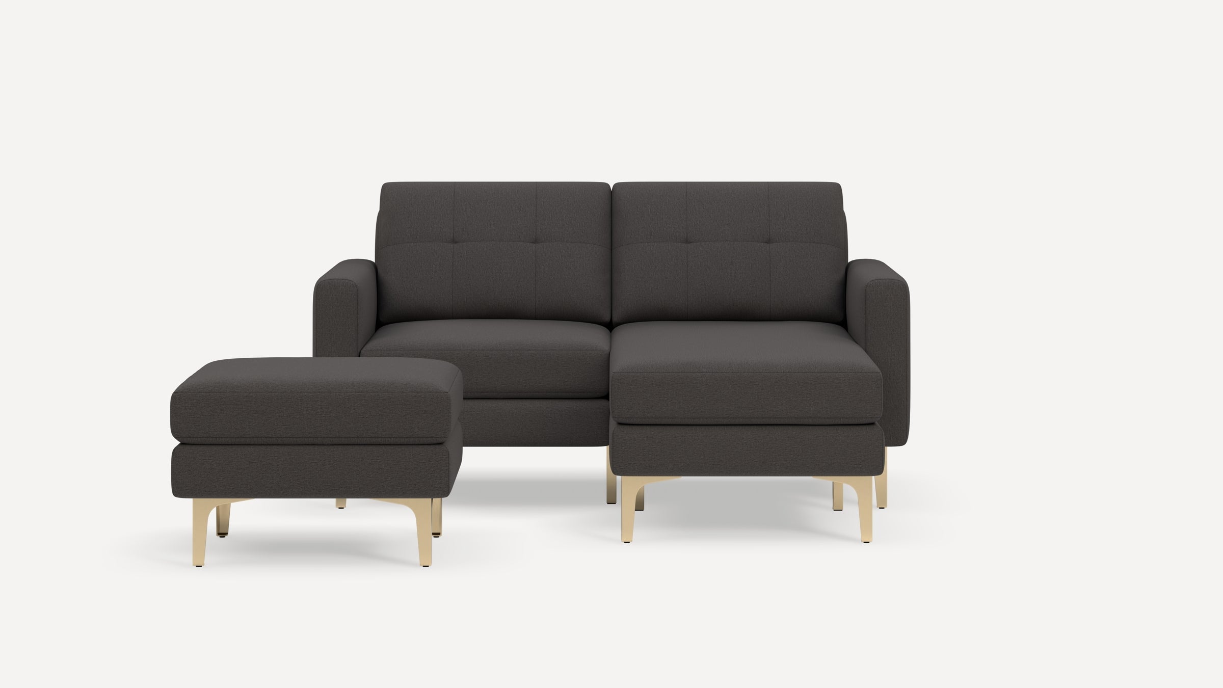 Dark gray fabric sectional sofa with tufted back cushions and matching ottoman, featuring gold-colored metal legs.