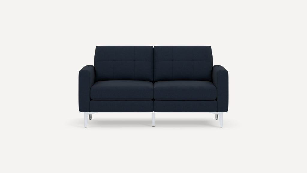 Modern two-seater sofa with dark navy blue upholstery, tufted back cushions, and sleek silver metal legs against a plain white background.