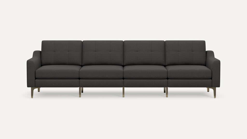 Contemporary four-seat dark gray fabric sofa with tufted cushions, curved armrests, and slim metallic legs.