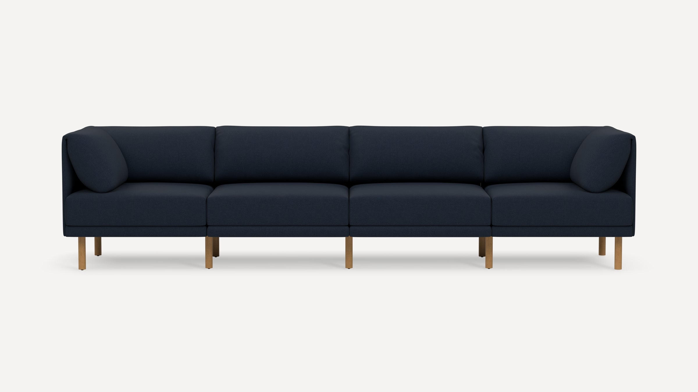 Modern navy blue four-seater sofa with plush cushions and light wooden legs, displayed against a plain white background.