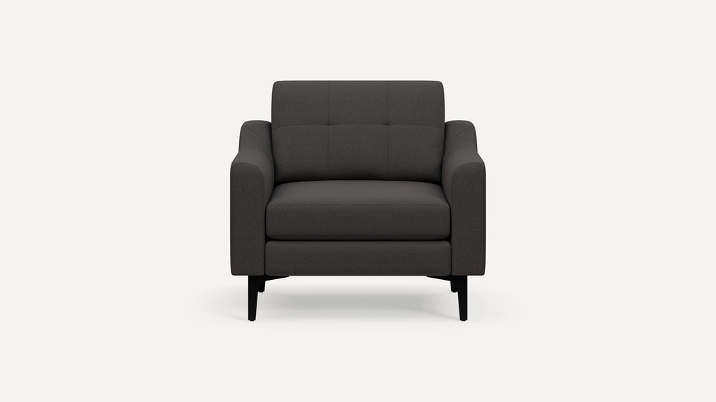 Front view of a modern, dark gray fabric armchair with black tapered legs and cushioned seat and backrest.