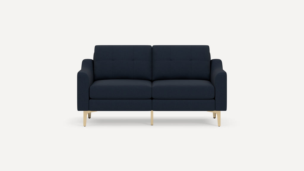 Modern navy blue fabric sofa with tufted back cushions and gold metal legs, shown against a white background.