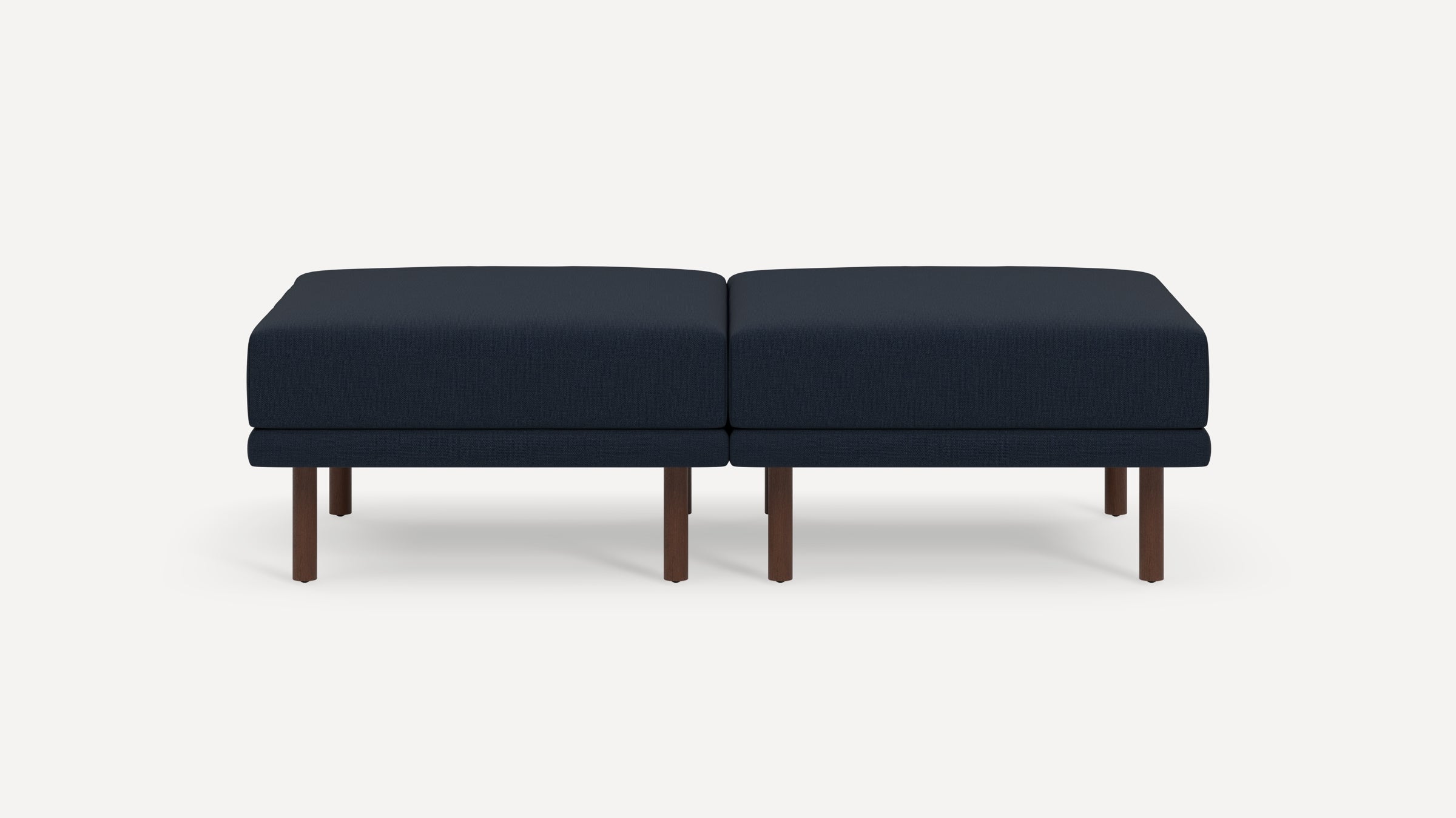Two navy blue cushioned ottomans with dark wooden legs placed side by side on a plain white background.