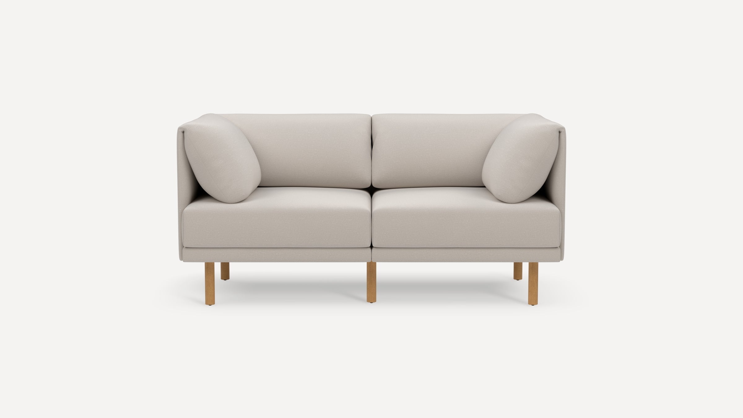 Modern two-seater sofa in light beige fabric with rounded cushions and wooden legs on a plain white background.