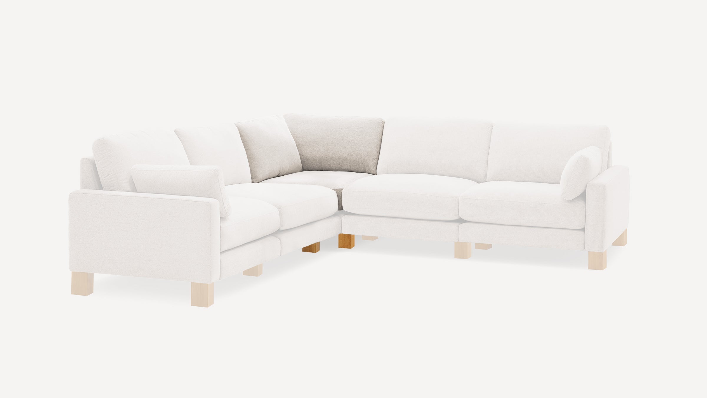 Modern L-shaped sectional sofa with light beige upholstery, wooden block legs, and matching and contrasting cushions in neutral tones.