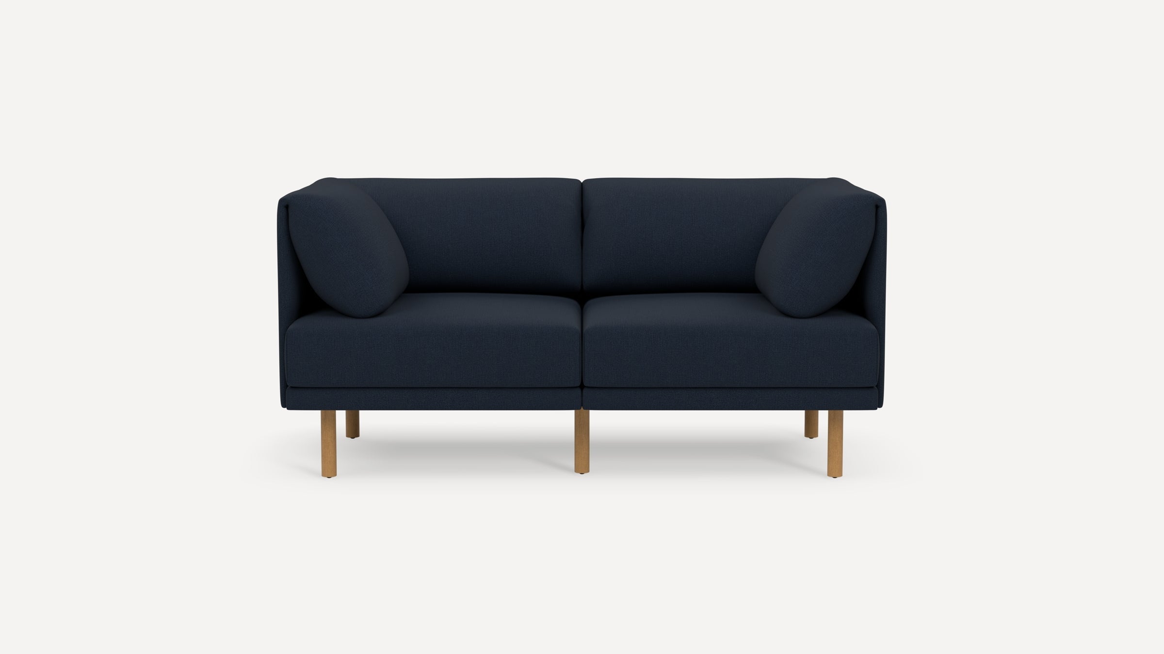 Modern navy blue two-seater sofa with rounded arm pillows and light wooden legs on a plain white background.