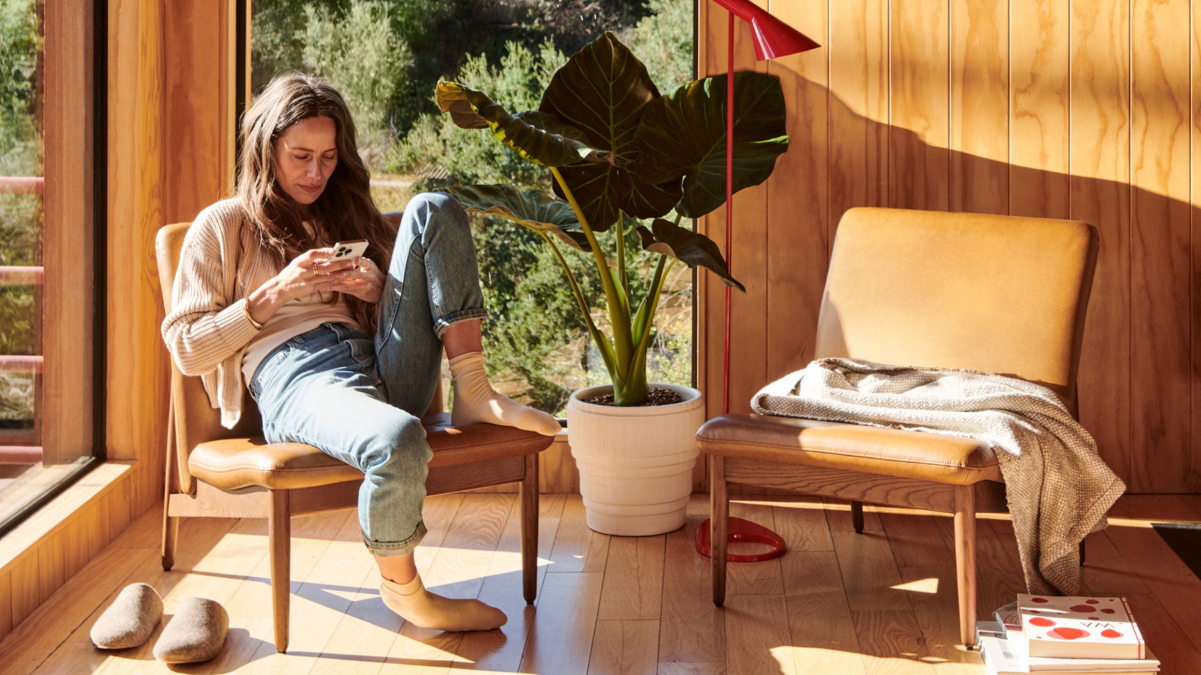 a woman sitting on a wooden chair using her phone